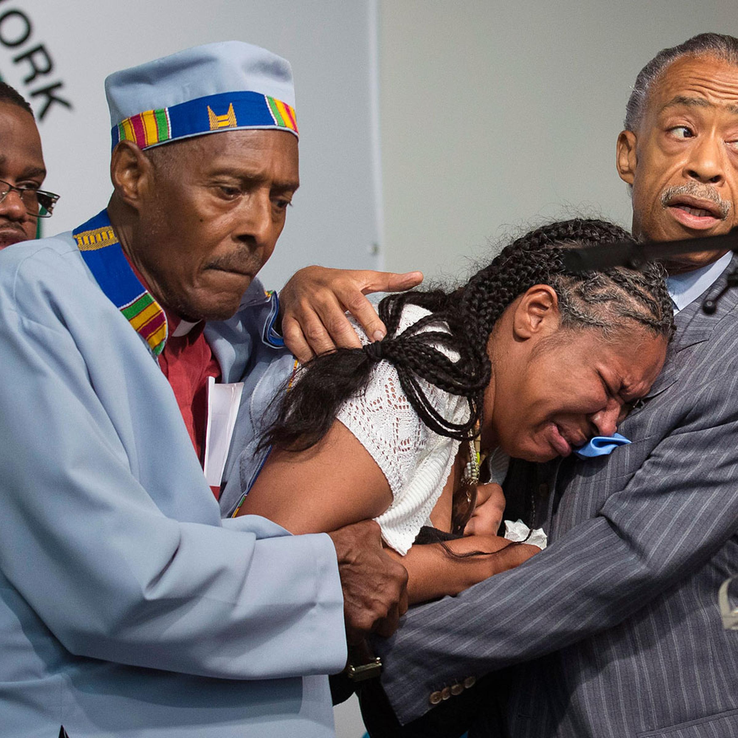 Rev. Herbert Daughtry and Rev. Al Sharpton hold Esaw Garner, wife of Eric Garner, during a rally at the National Action Network headquarters for Eric Garner, July 19, 2014, in New York City.