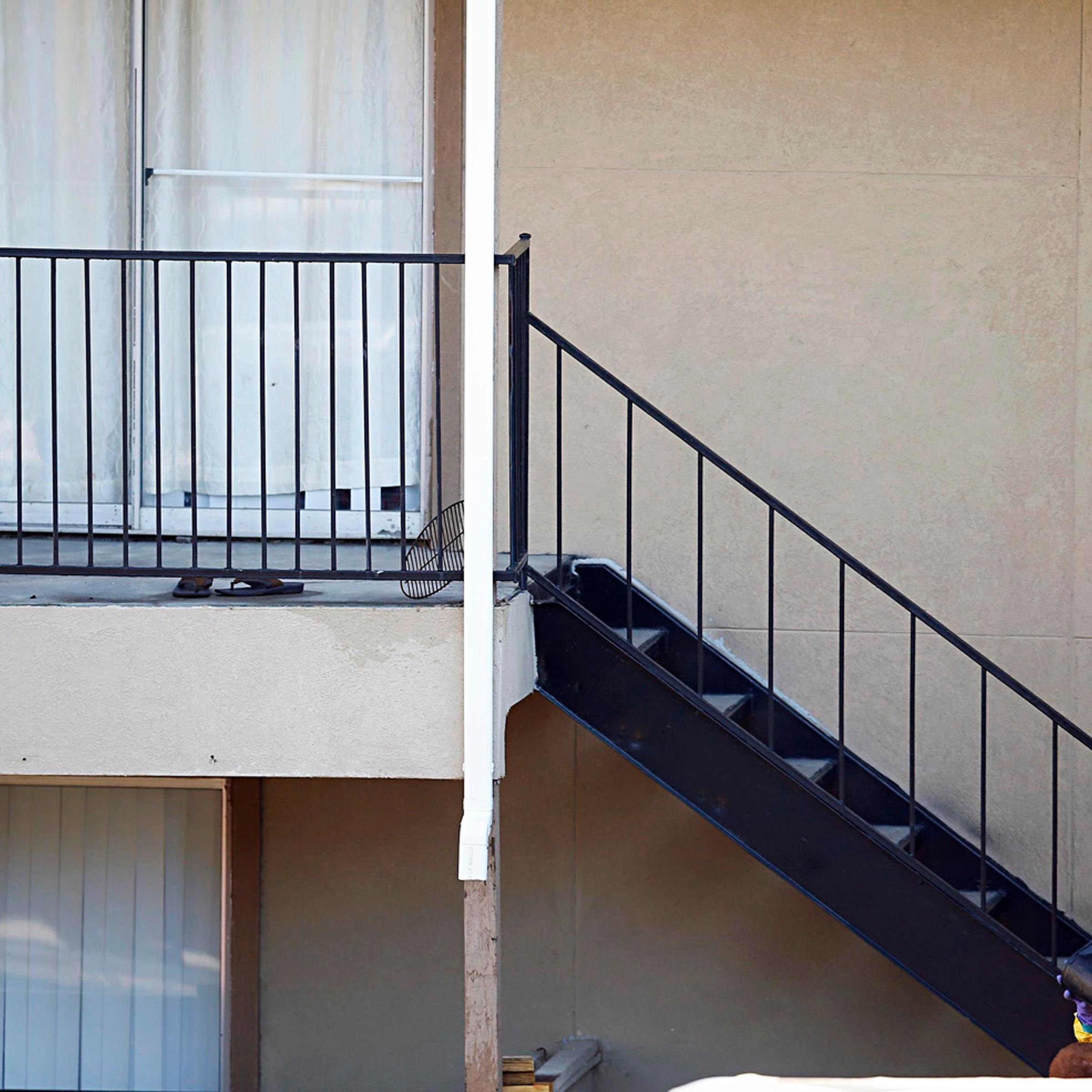 Neighboring people watch a man in a hazardous material suit work on cleaning the apartment unit where a man diagnosed with the Ebola virus was staying in Dallas