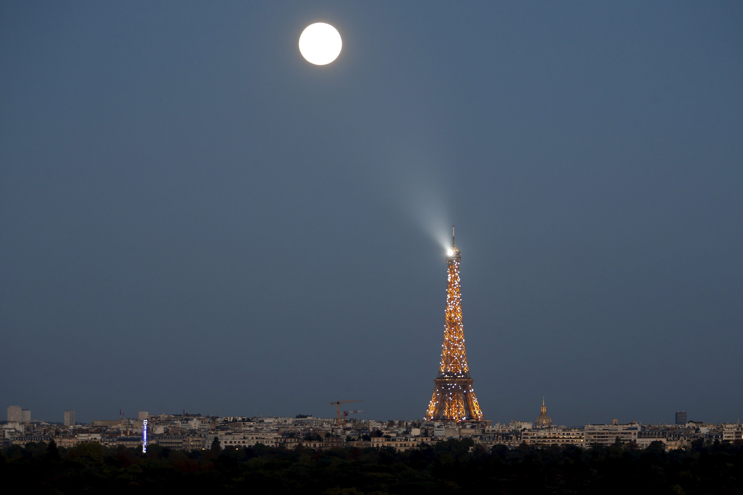 A super moon rises in the sky near the Eiffel tower as seen from Suresnes, Western Paris