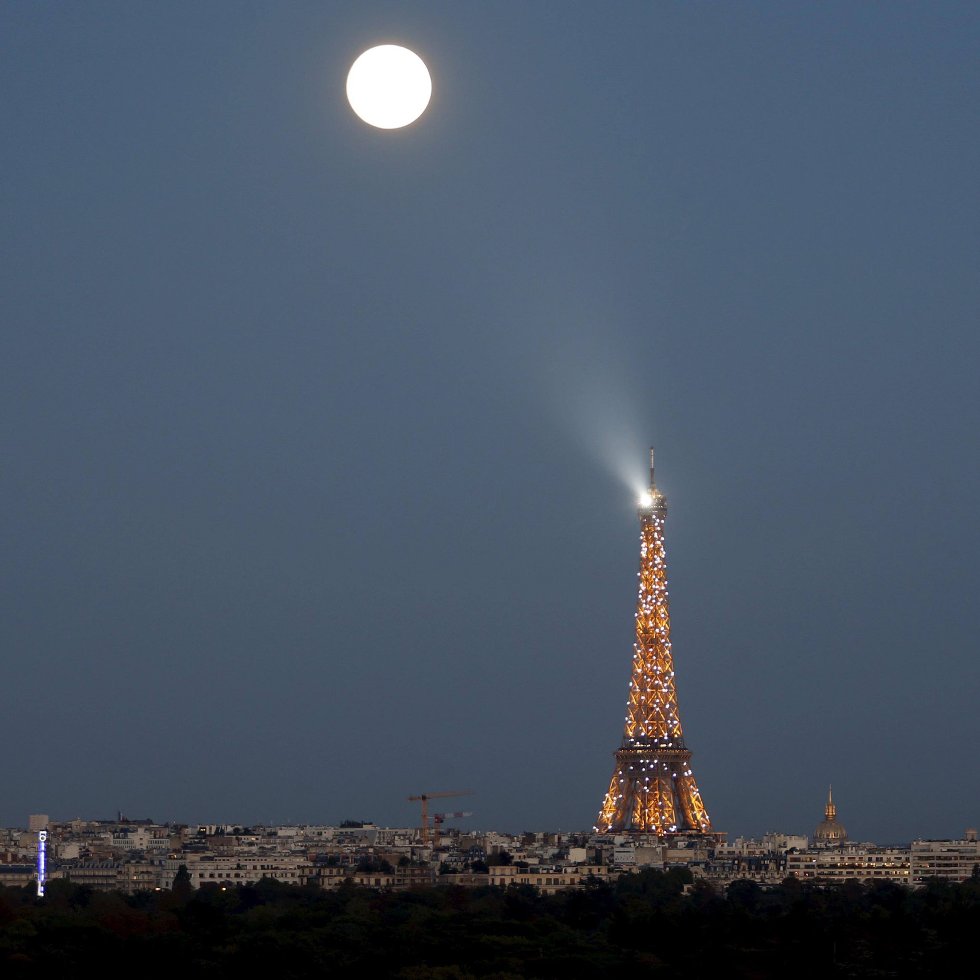 A super moon rises in the sky near the Eiffel tower as seen from Suresnes, Western Paris