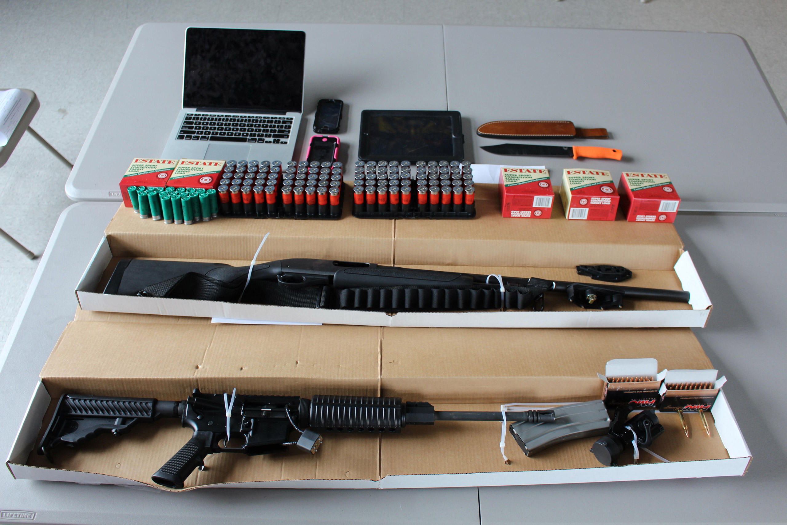 This photo, provided by the Boston Police Department, shows a 12-gauge Remington shotgun, a DPM5 Model AR-15 rifle, several hundred rounds of ammunition, and a hunting knife, confiscated by the police in Boston on Aug. 21, 2015.