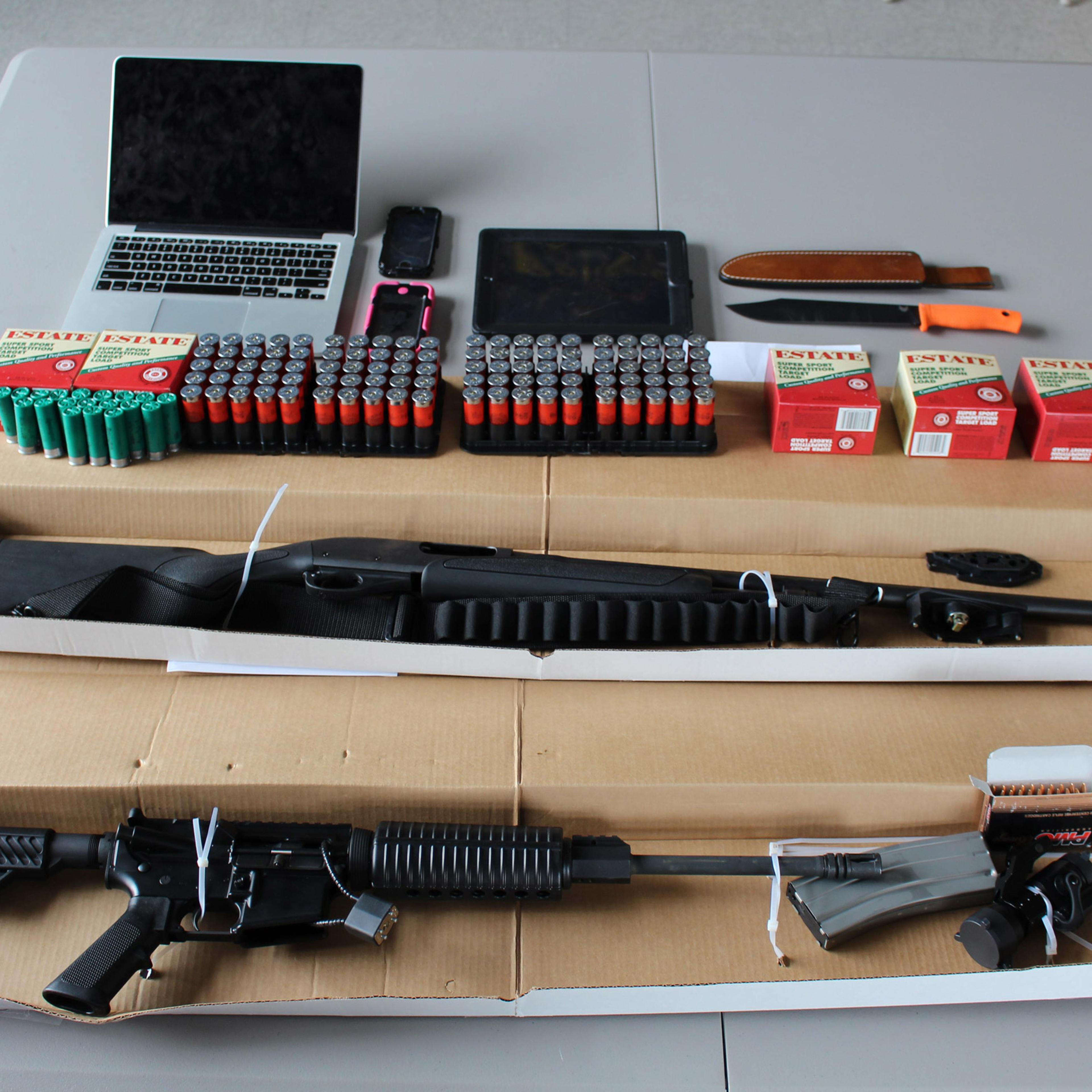 This photo, provided by the Boston Police Department, shows a 12-gauge Remington shotgun, a DPM5 Model AR-15 rifle, several hundred rounds of ammunition, and a hunting knife, confiscated by the police in Boston on Aug. 21, 2015.