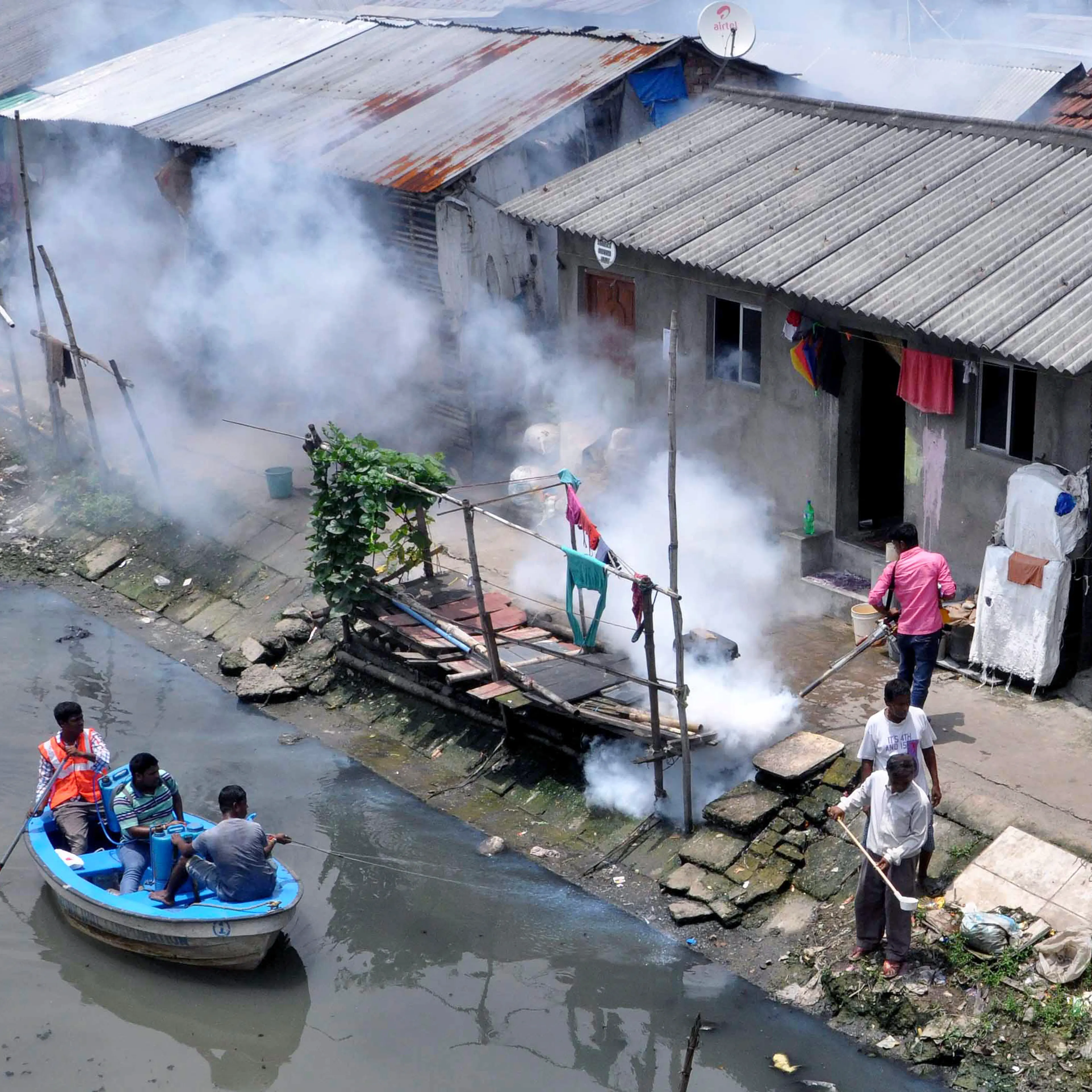 Municipal workers spray chemicals in canal and other worker