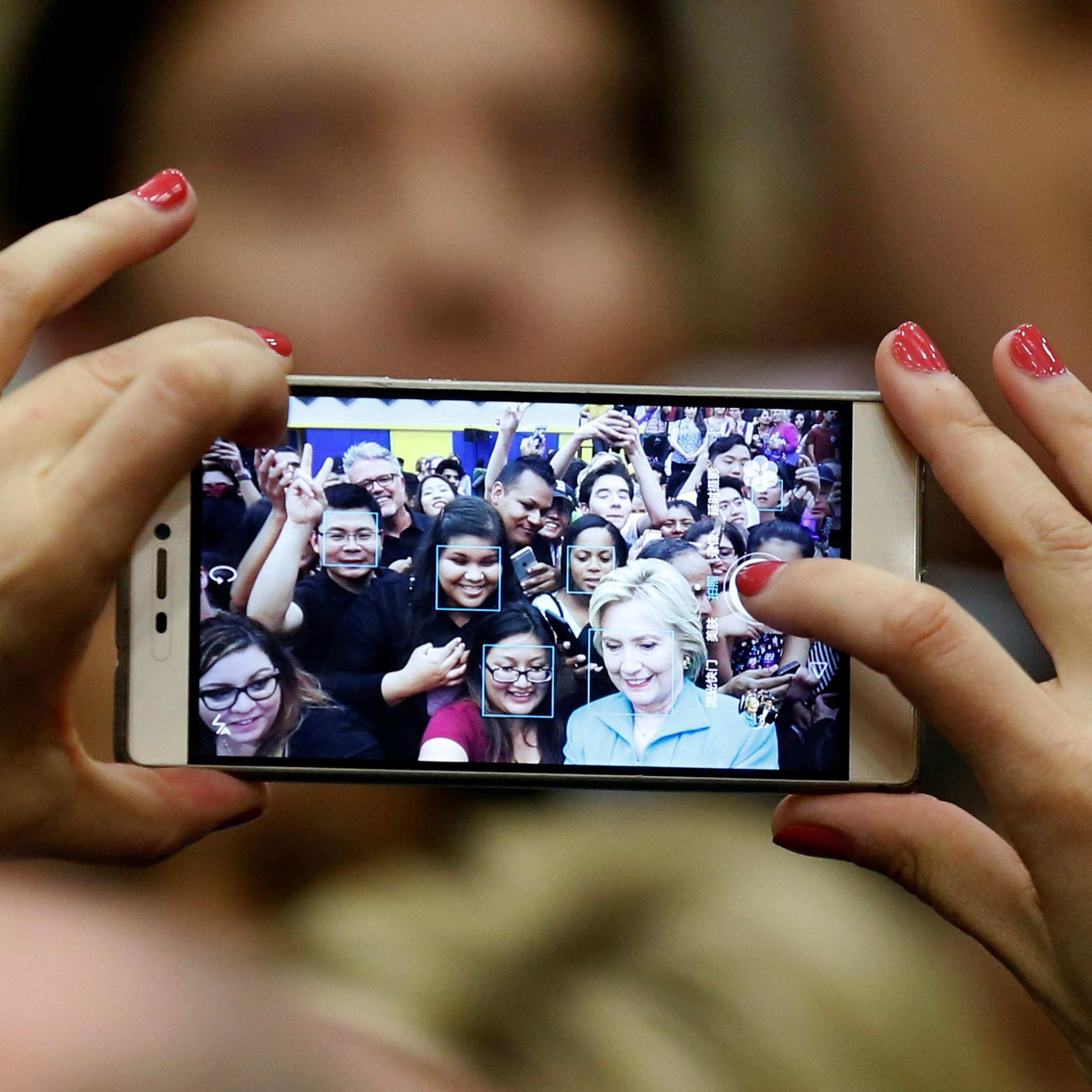 U.S. Democratic presidential candidate Hillary Clinton takes a selfie with supporters after speaking at the University of California Riverside in Riverside, California, U.S. May 24, 2016. REUTERS/Lucy Nicholson