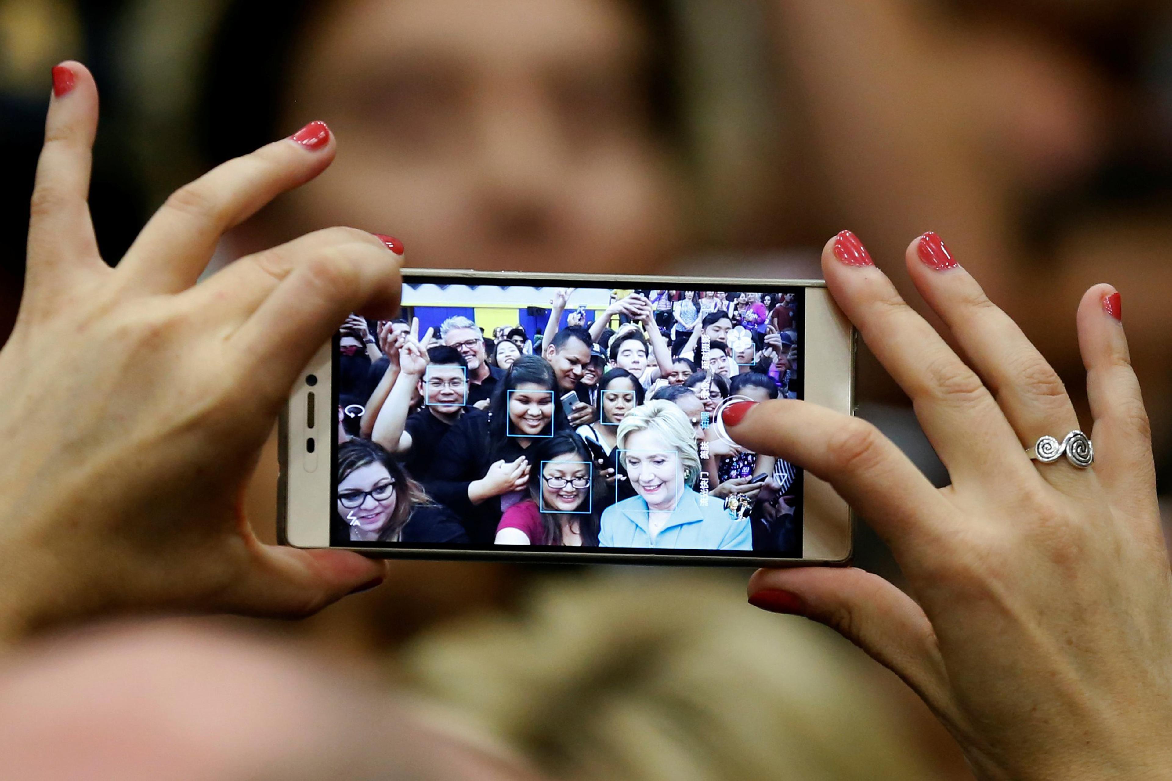 U.S. Democratic presidential candidate Hillary Clinton takes a selfie with supporters after speaking at the University of California Riverside in Riverside, California, U.S. May 24, 2016. REUTERS/Lucy Nicholson