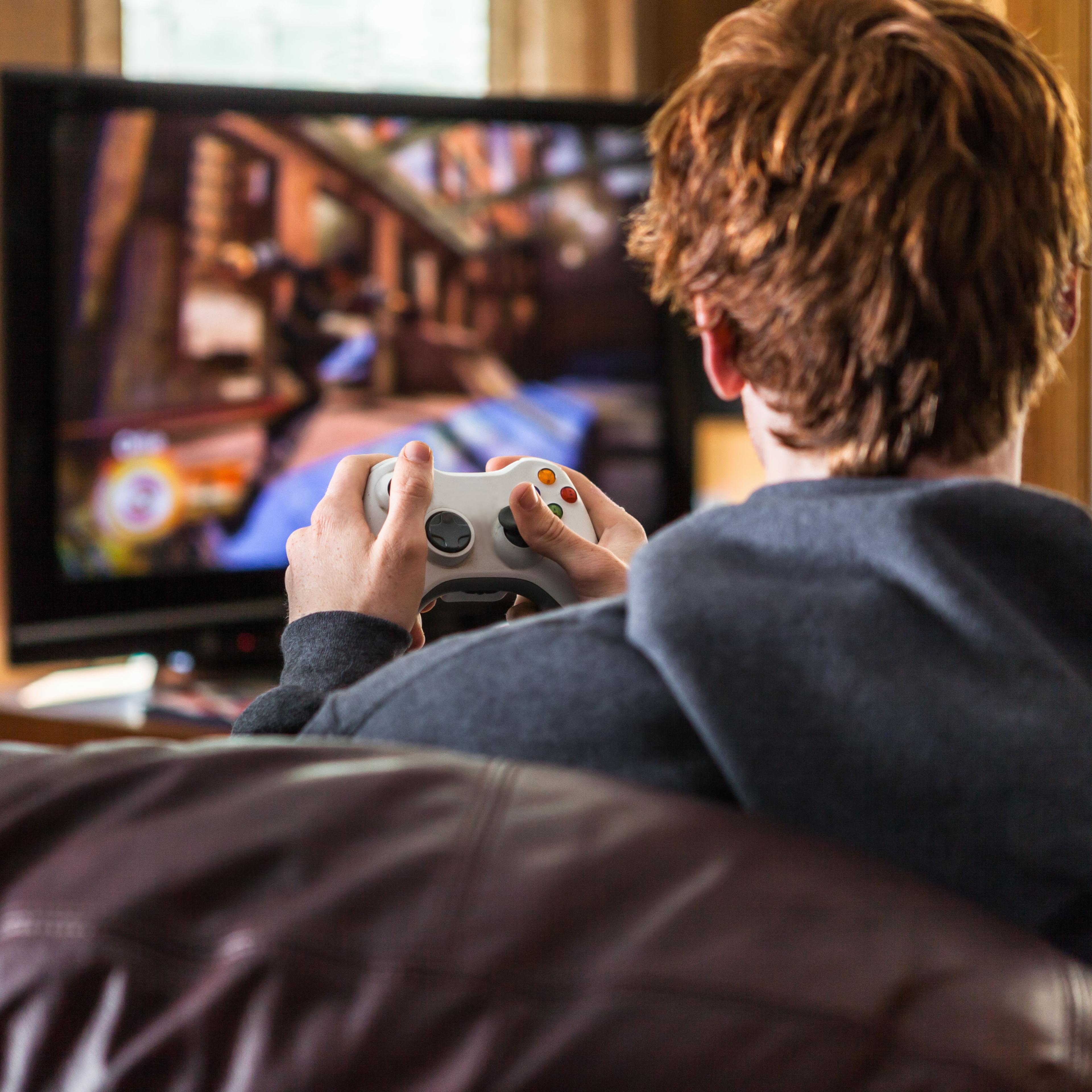 A teenager plays video games at home