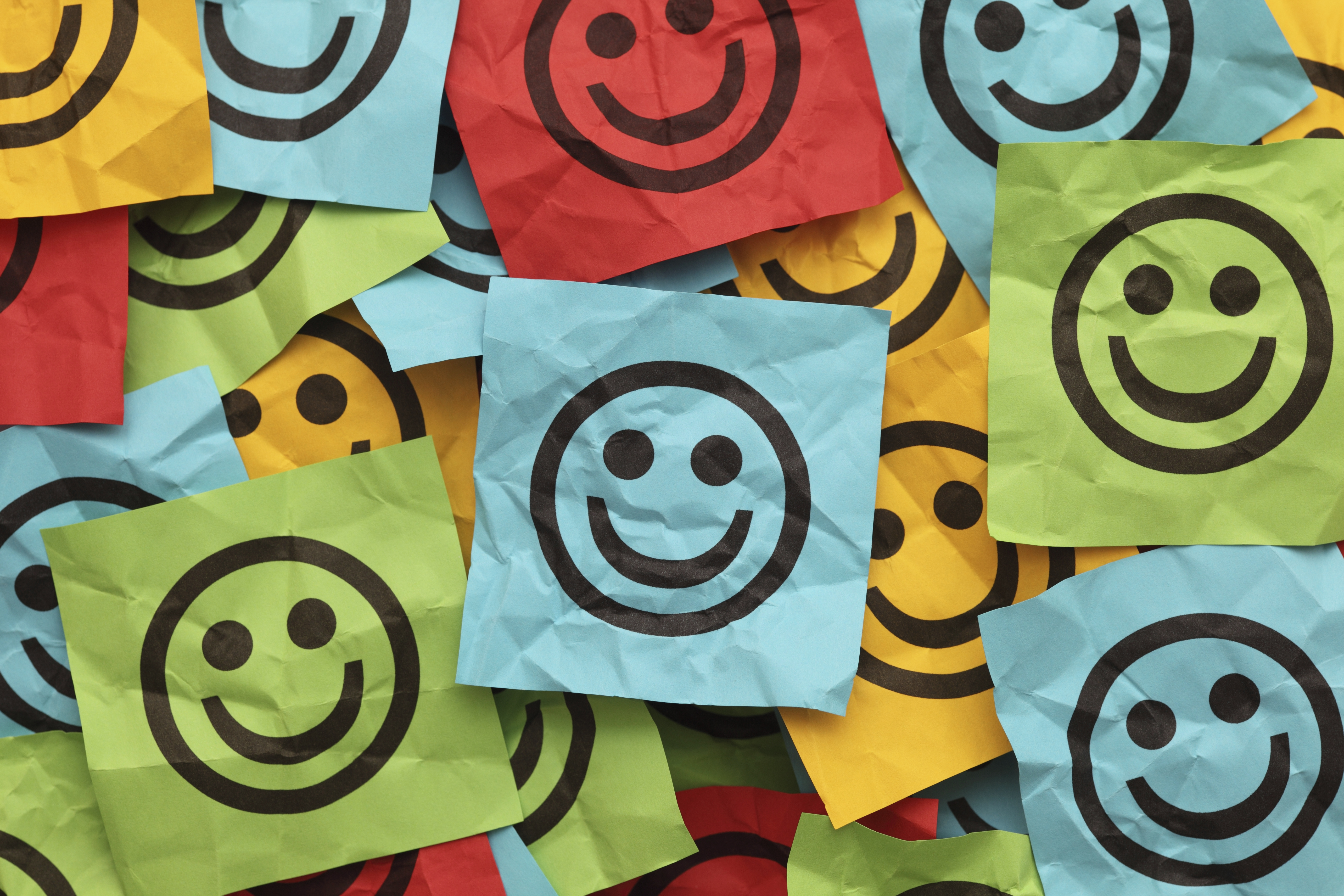 Crumpled adhesive notes with smiling faces