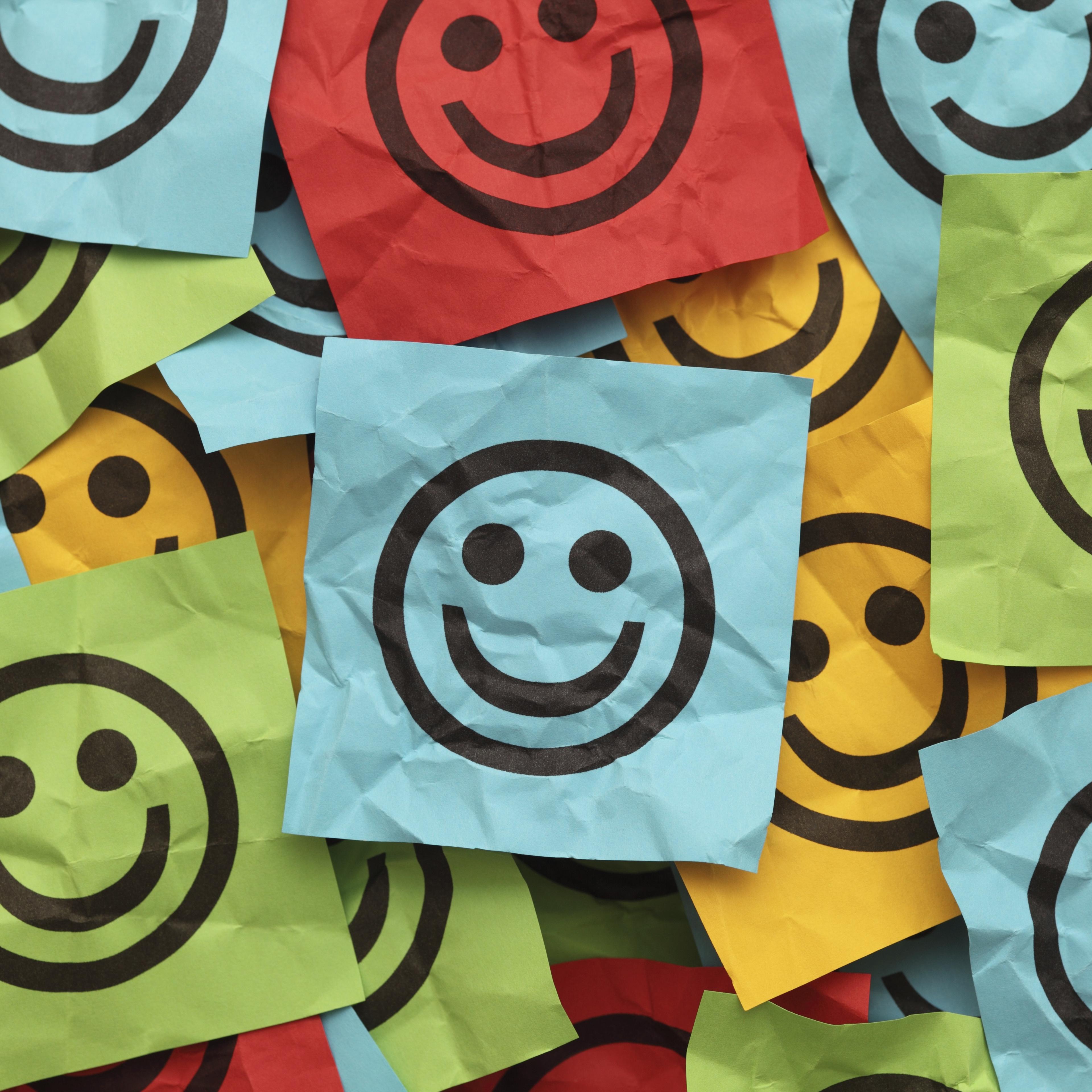 Crumpled adhesive notes with smiling faces