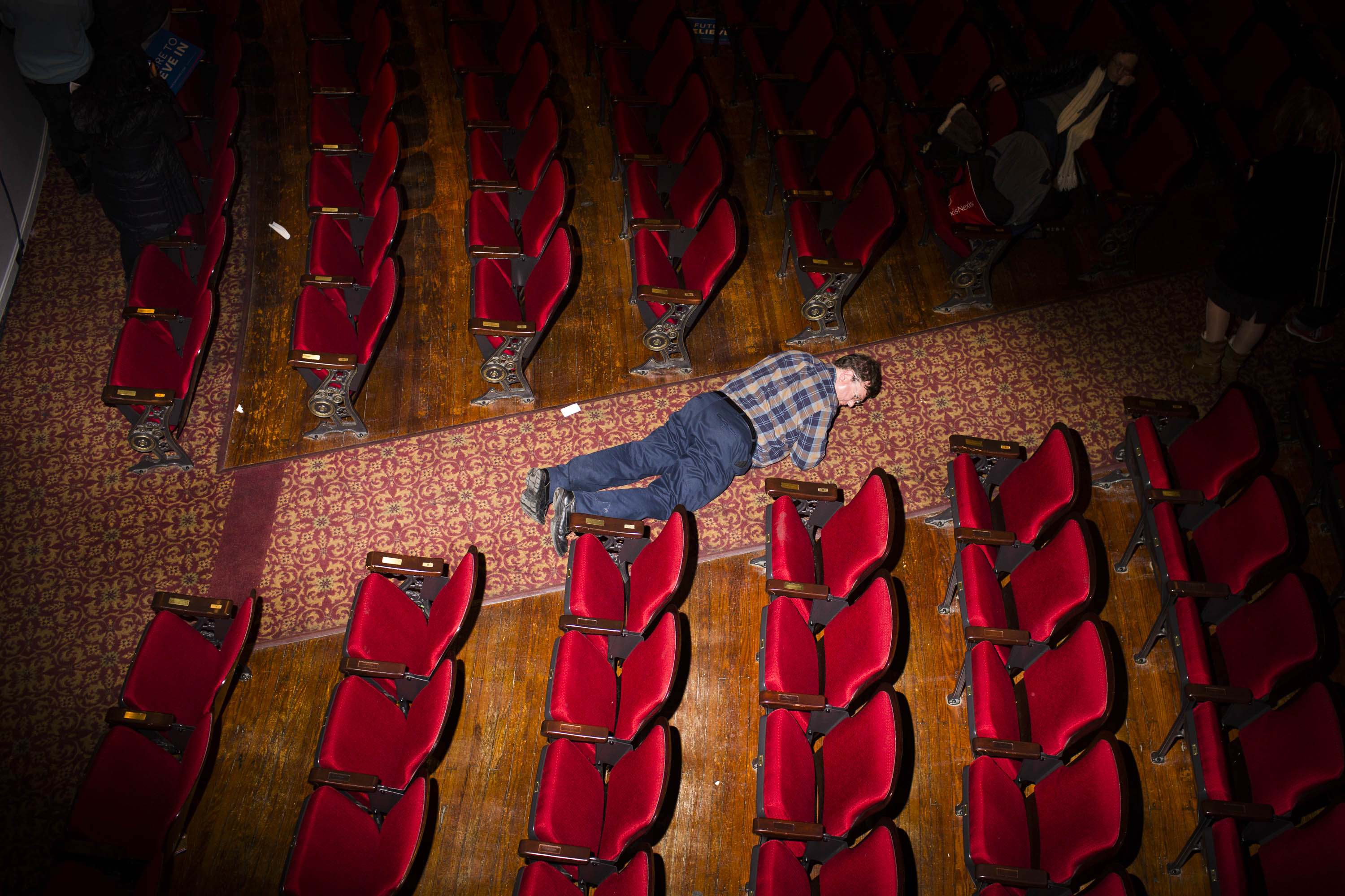 A man looks for something he dropped at the Palace Theater, where Democratic presidential candidate, Vermont Sen. Bernie Sanders held a campaign event on Feb. 8, 2016, in Manchester, N.H.