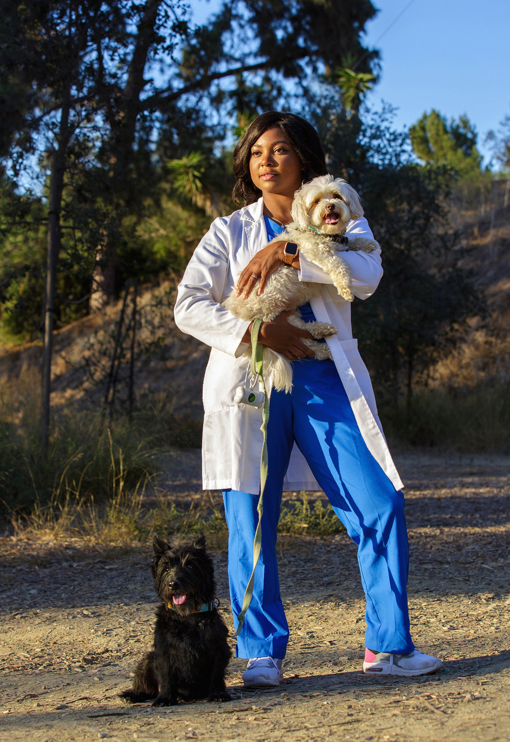 Tierra Price holds Flossie in her arms while Rocco sits at her feet during a visit to a dog park in Culver City, Calif., on Oct 12.