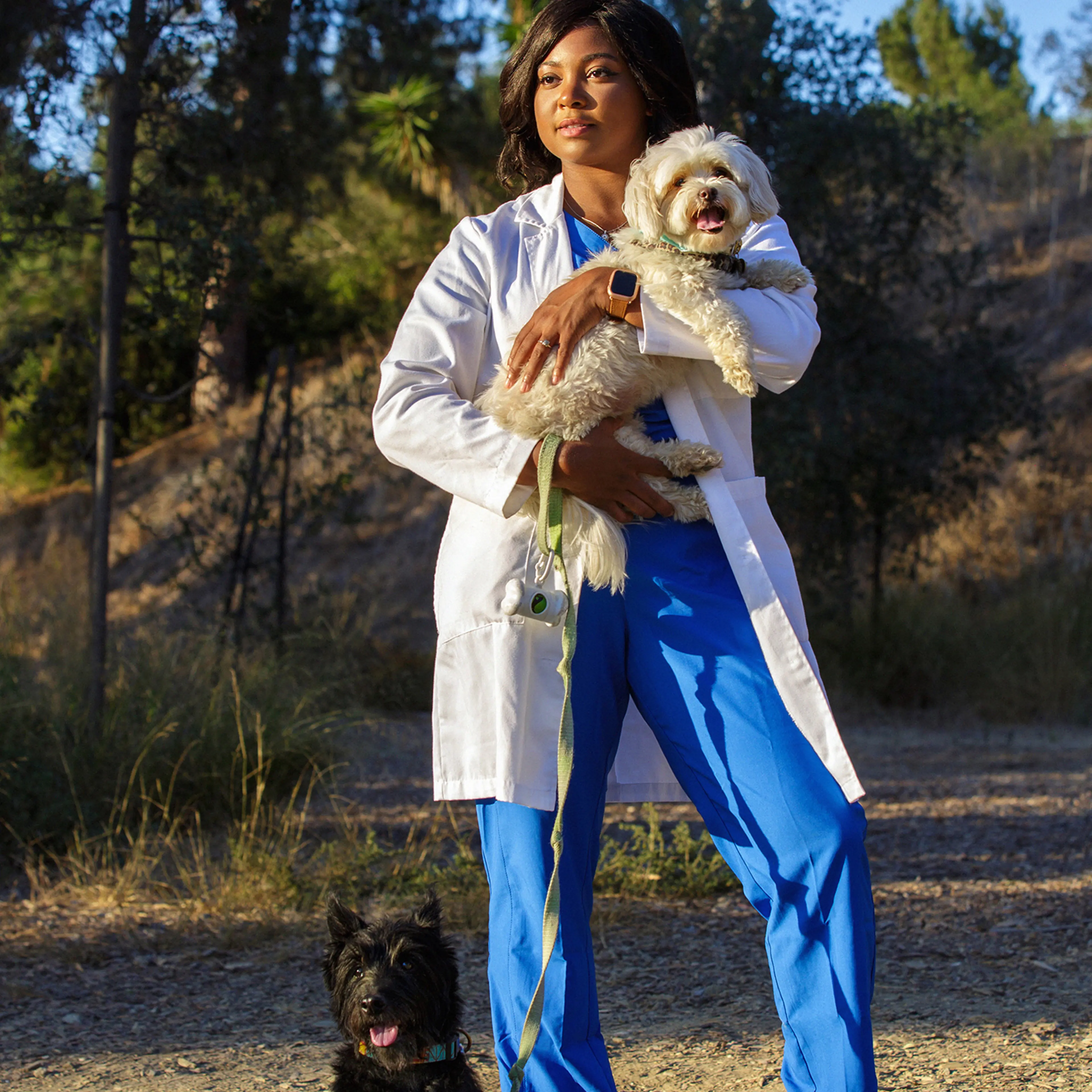 Tierra Price holds Flossie in her arms while Rocco sits at her feet during a visit to a dog park in Culver City, Calif., on Oct 12.