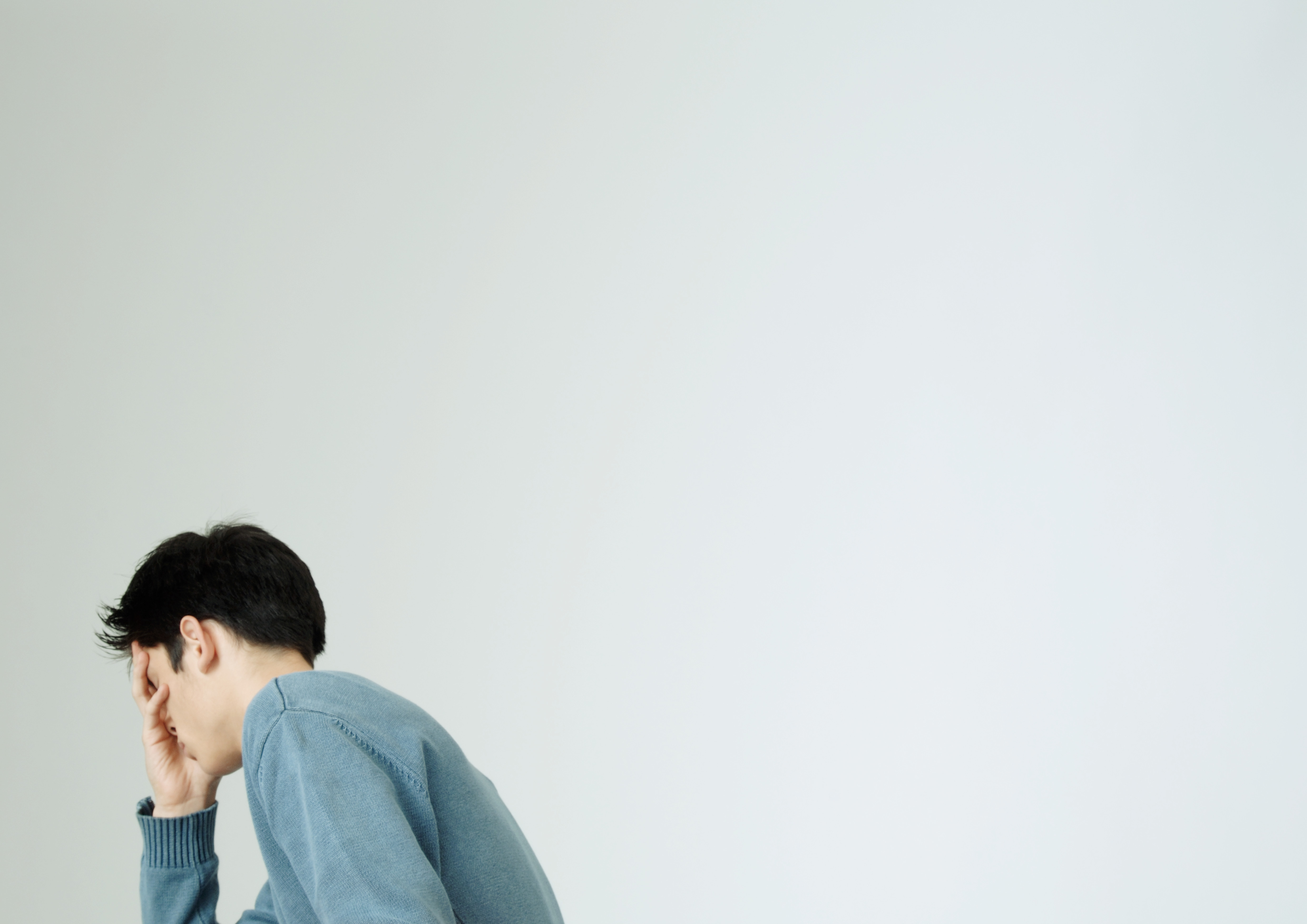 Young man covering face with hand TIME health stock