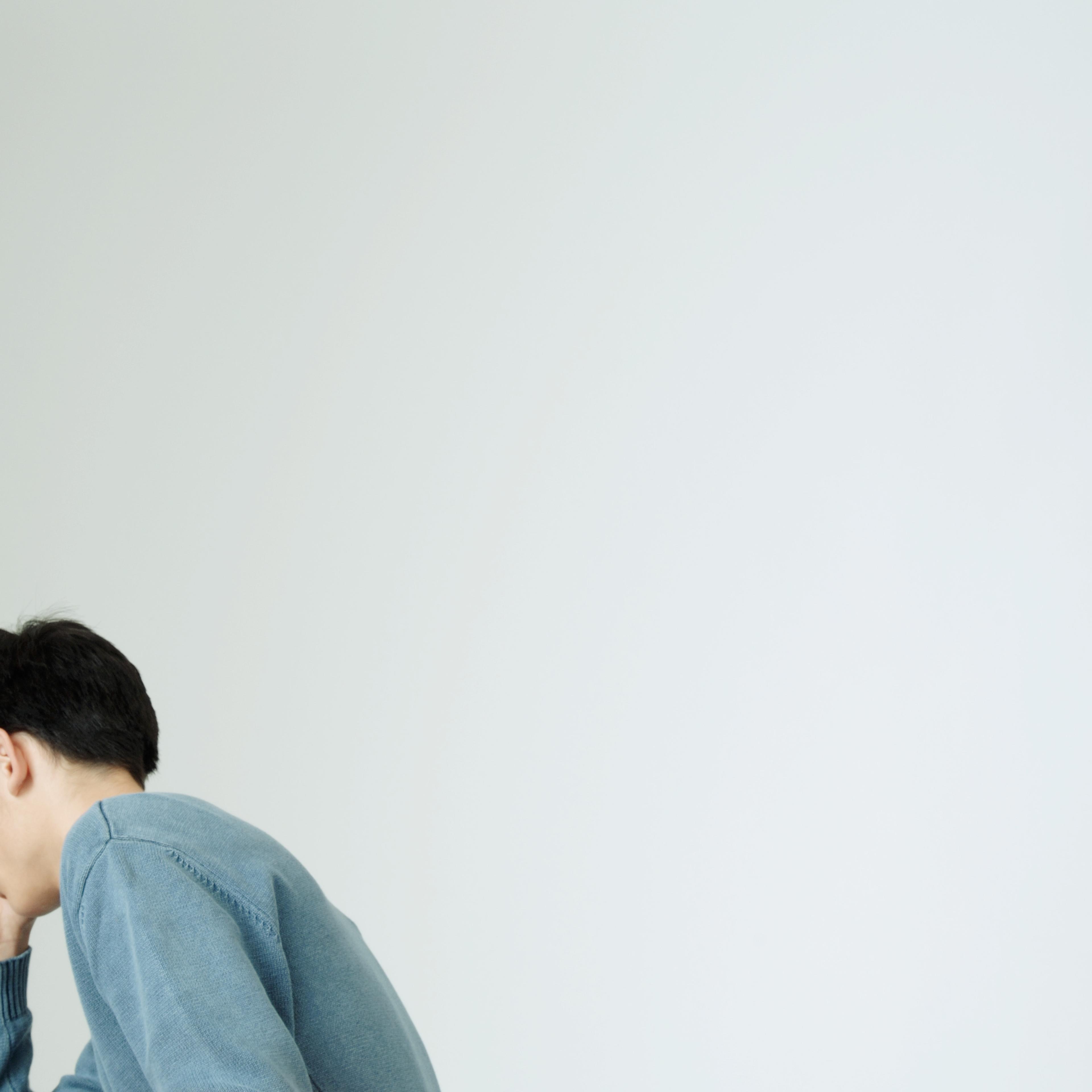 Young man covering face with hand TIME health stock