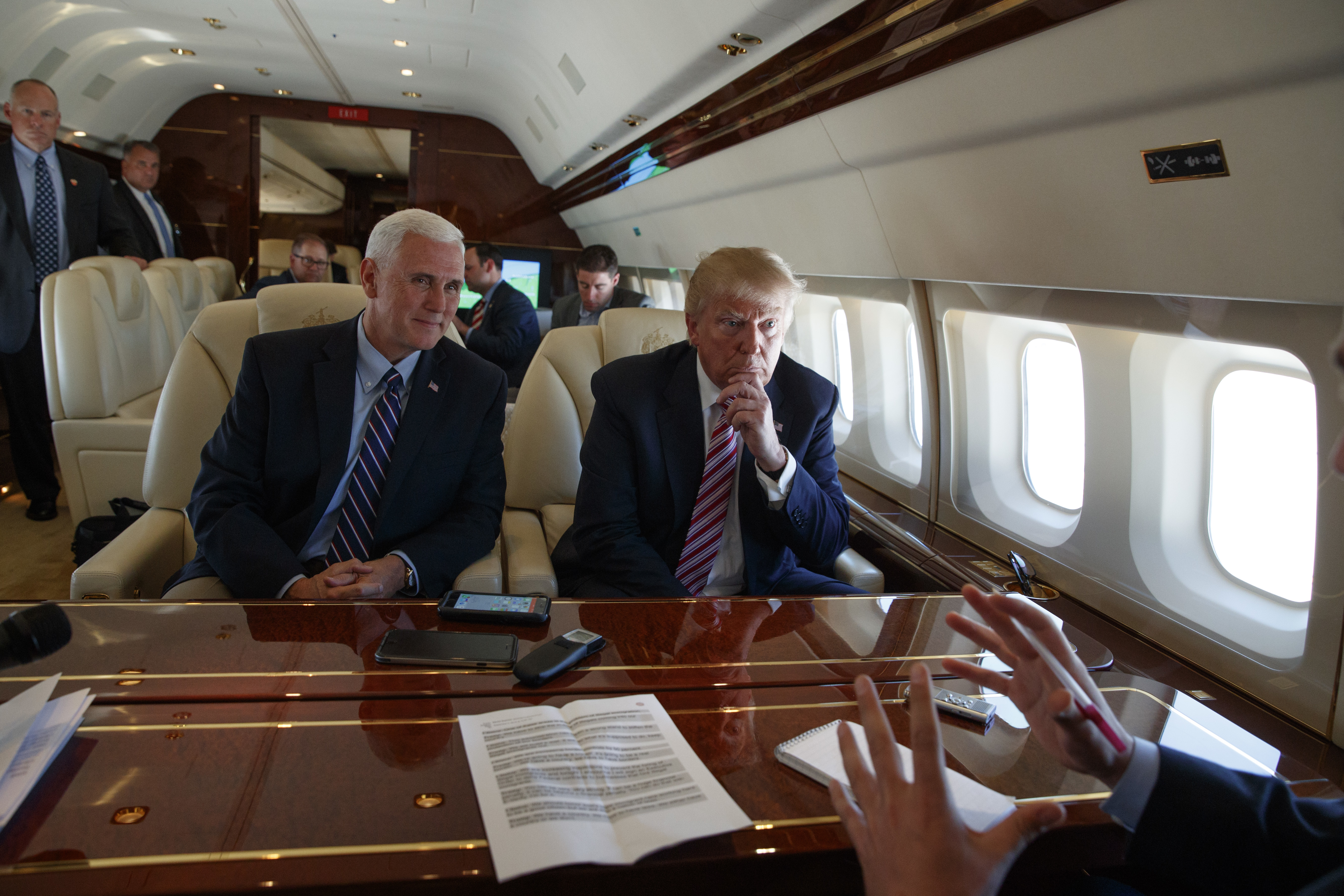 Republican presidential candidate Donald Trump talks with press, Sept. 5, 2016, aboard his campaign plane while flying over Ohio, as Vice presidential candidate Gov. Mike Pence, R-Ind., left, looks on.