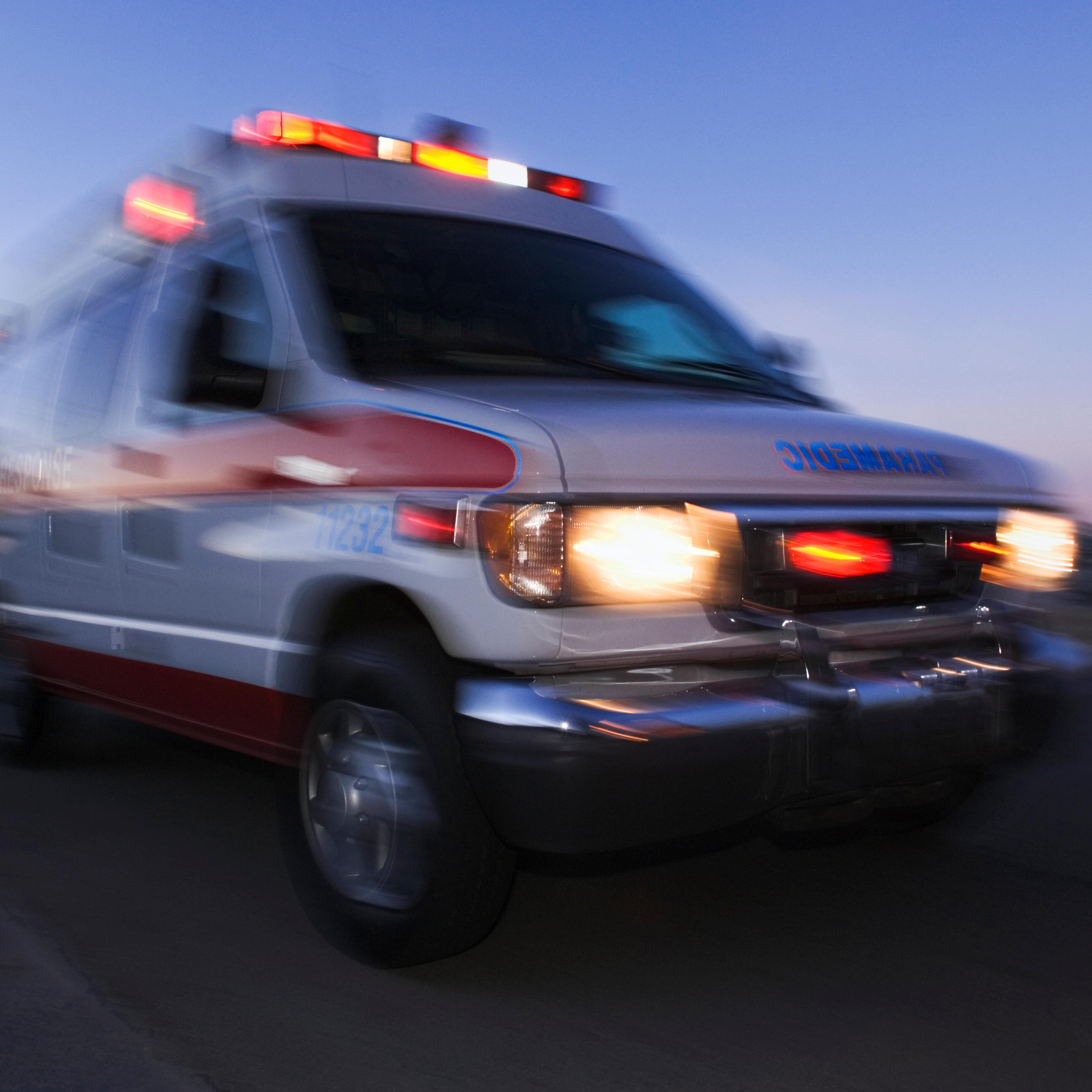 Blurred view of ambulance driving at dusk
