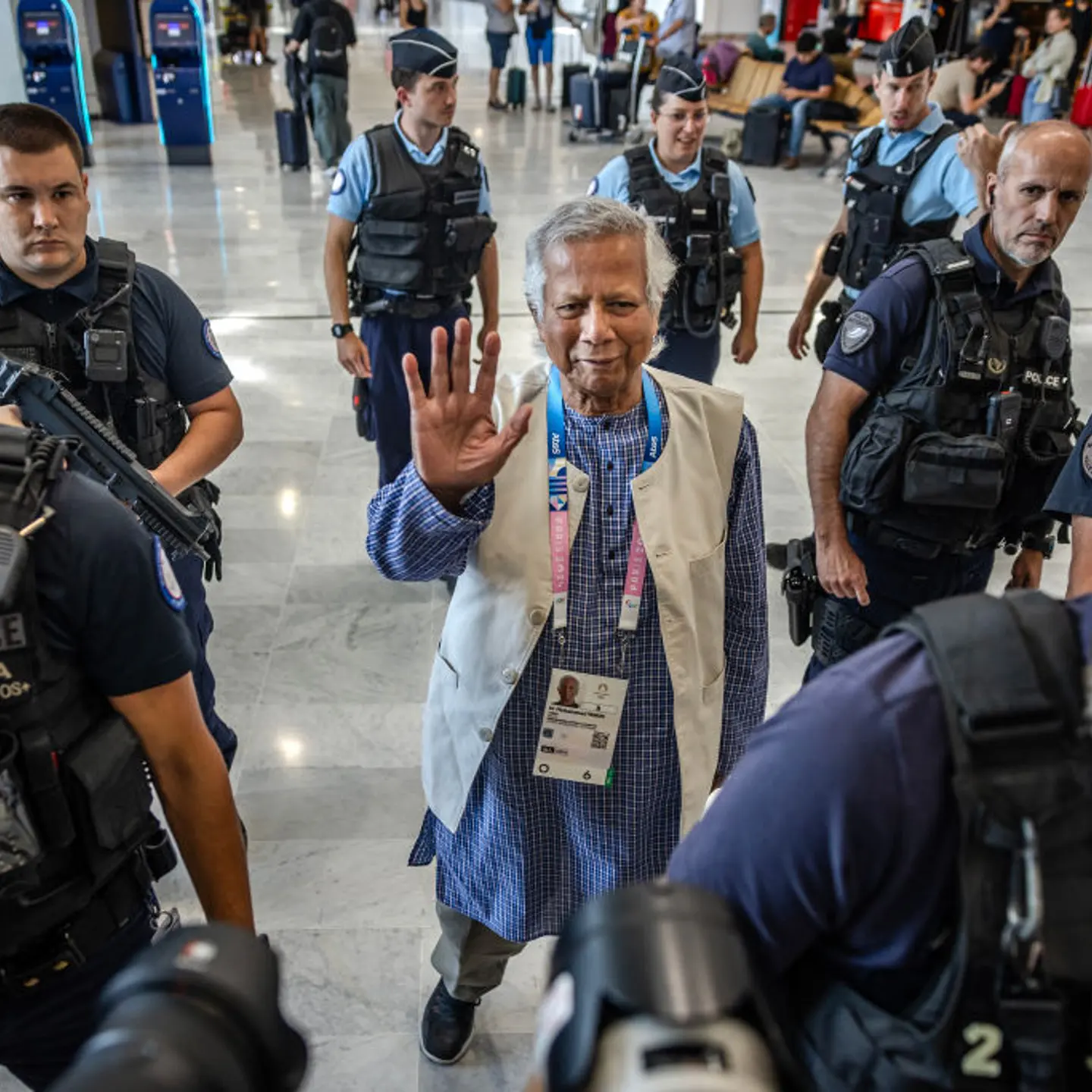 Bangladesh's finance pioneer Muhammad Yunus (C) is escorted by French police personnel as he arrives at Roissy-Charles de Gaulle Airport, north of Paris on August 7, 2024, enroute to Bangladesh.