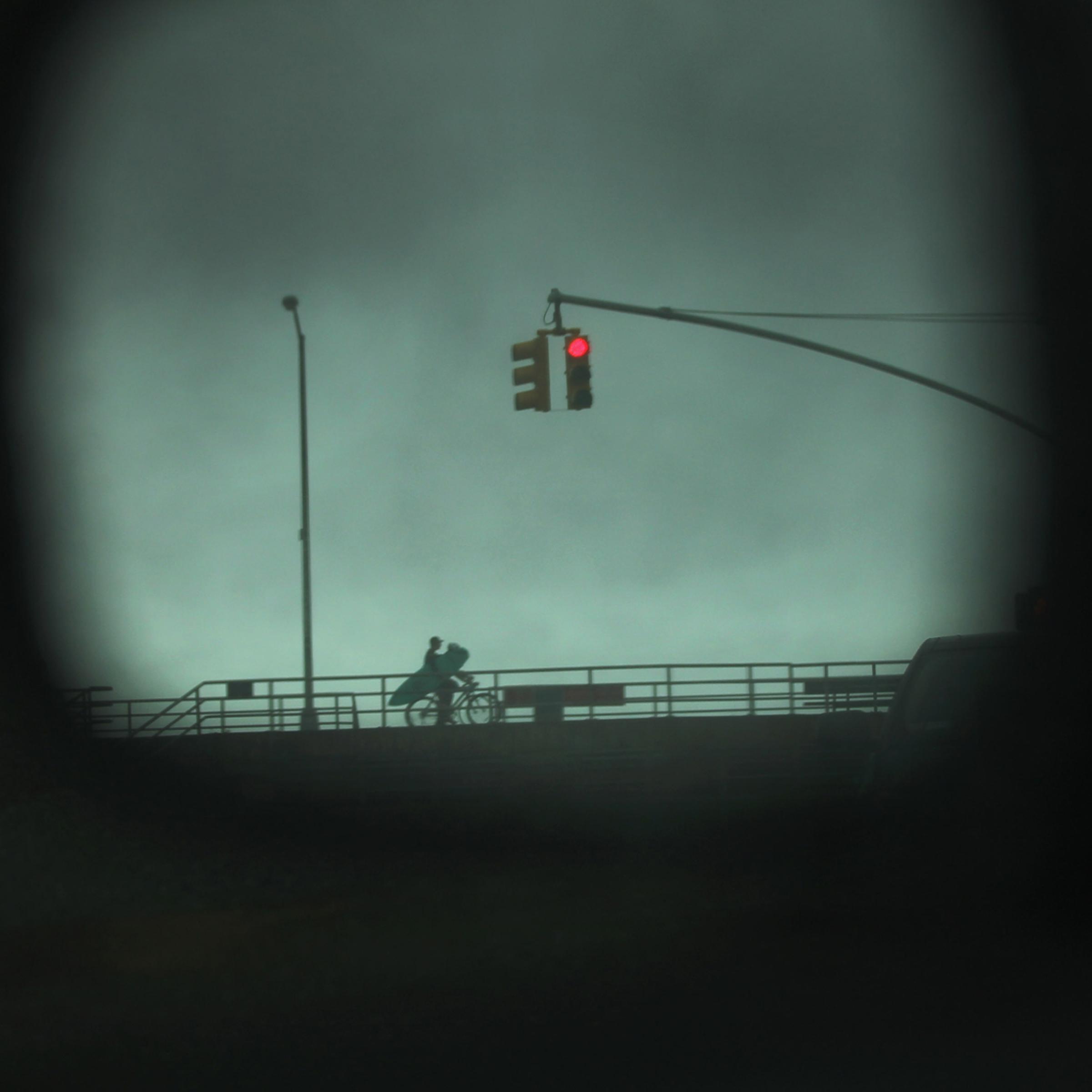 August 27, 2011, New York, NY. A surfer is viewed on his bike through a car mirror in the Rockaways before the arrival of Hurricane Irene. The Rockaways were under mandatory evacuation orders.