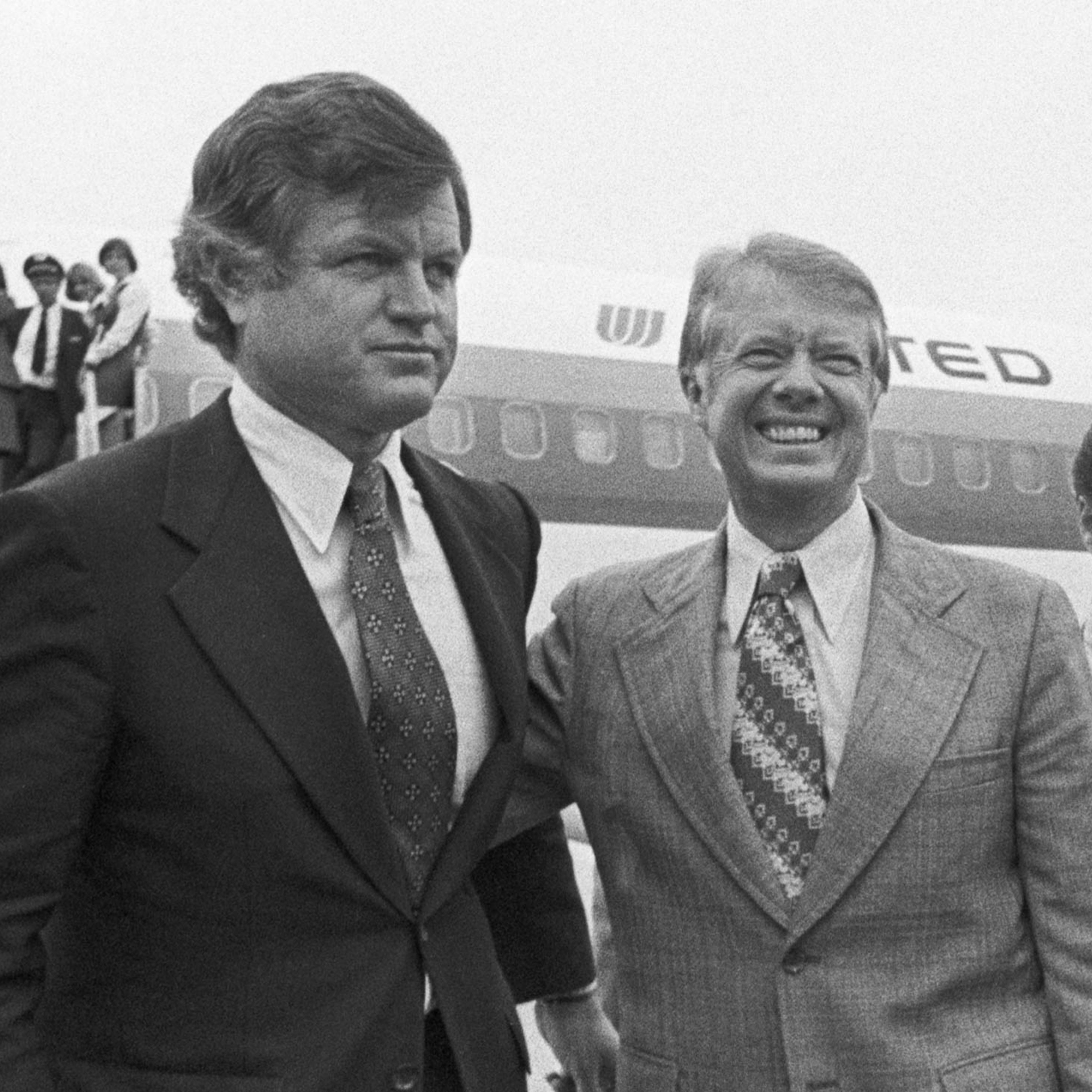 Pictured (center), Democratic presidential nominee Jimmy Carter, (R), puts his arm around Senator Edward M. Kennedy (L) as he arrived at Logan International Airport in Boston on Sep. 30, 1976, for a four-hour campaign blitz.