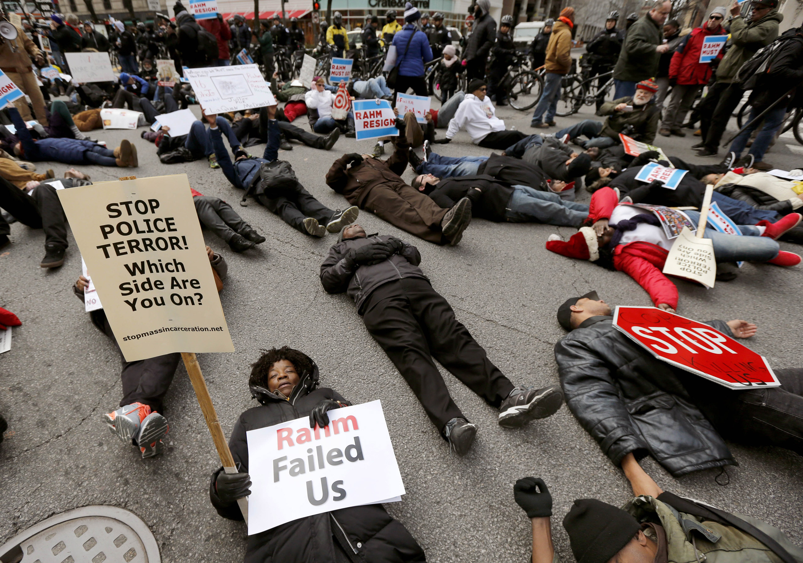 Protesters block an intersection on Chicago's Magnificent Mile, calling for the resignation of Mayor Rahm Emanuel, Thursday, Dec. 24, 2015, in Chicago. The Christmas Eve protest is the latest in a series of demonstrations in the city since the release la