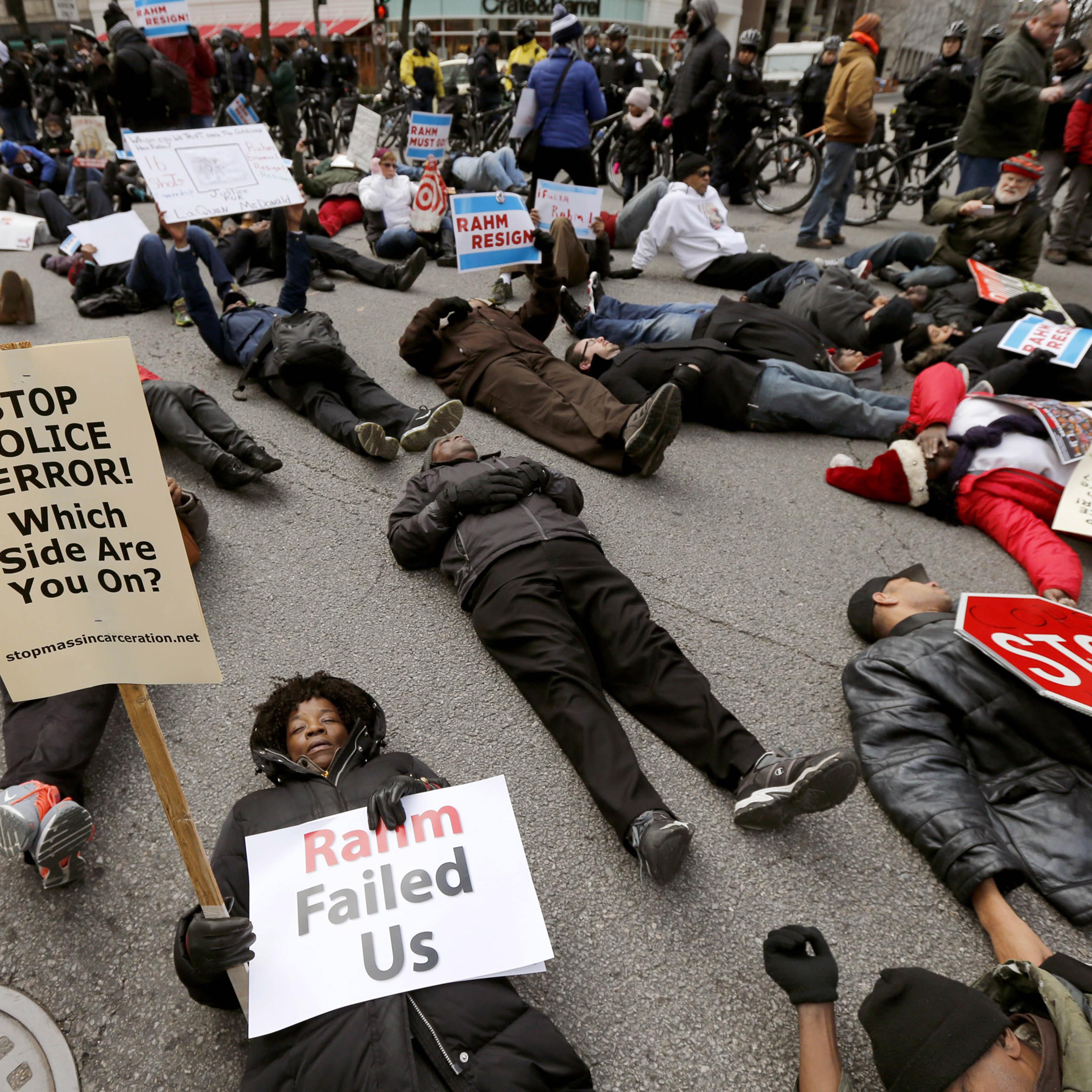 Protesters block an intersection on Chicago's Magnificent Mile, calling for the resignation of Mayor Rahm Emanuel, Thursday, Dec. 24, 2015, in Chicago. The Christmas Eve protest is the latest in a series of demonstrations in the city since the release la