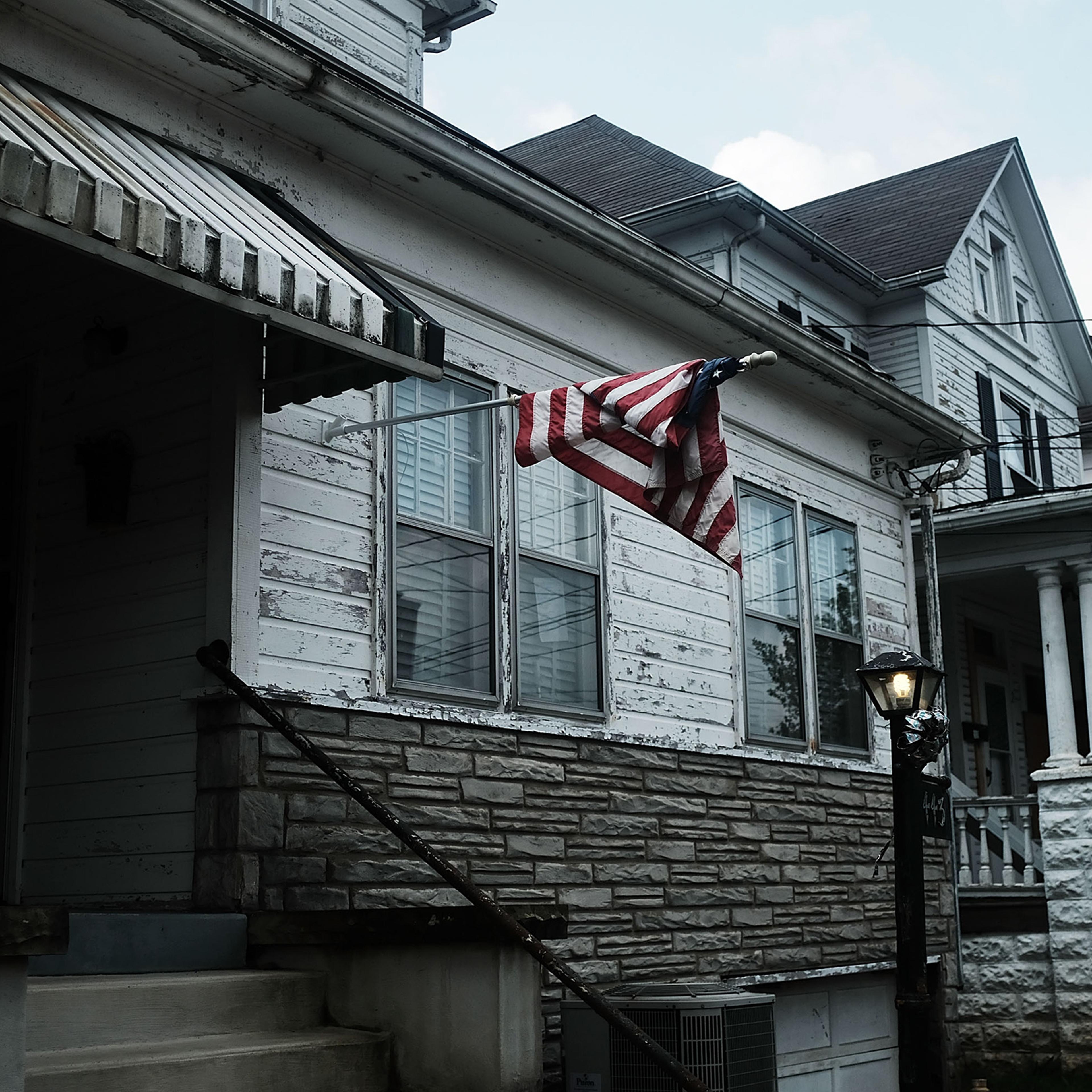 An American flag hangs outside of a home in Clarksburg, WV on Aug. 22, 2018, a state still struggling with endemic poverty and opioid abuse.