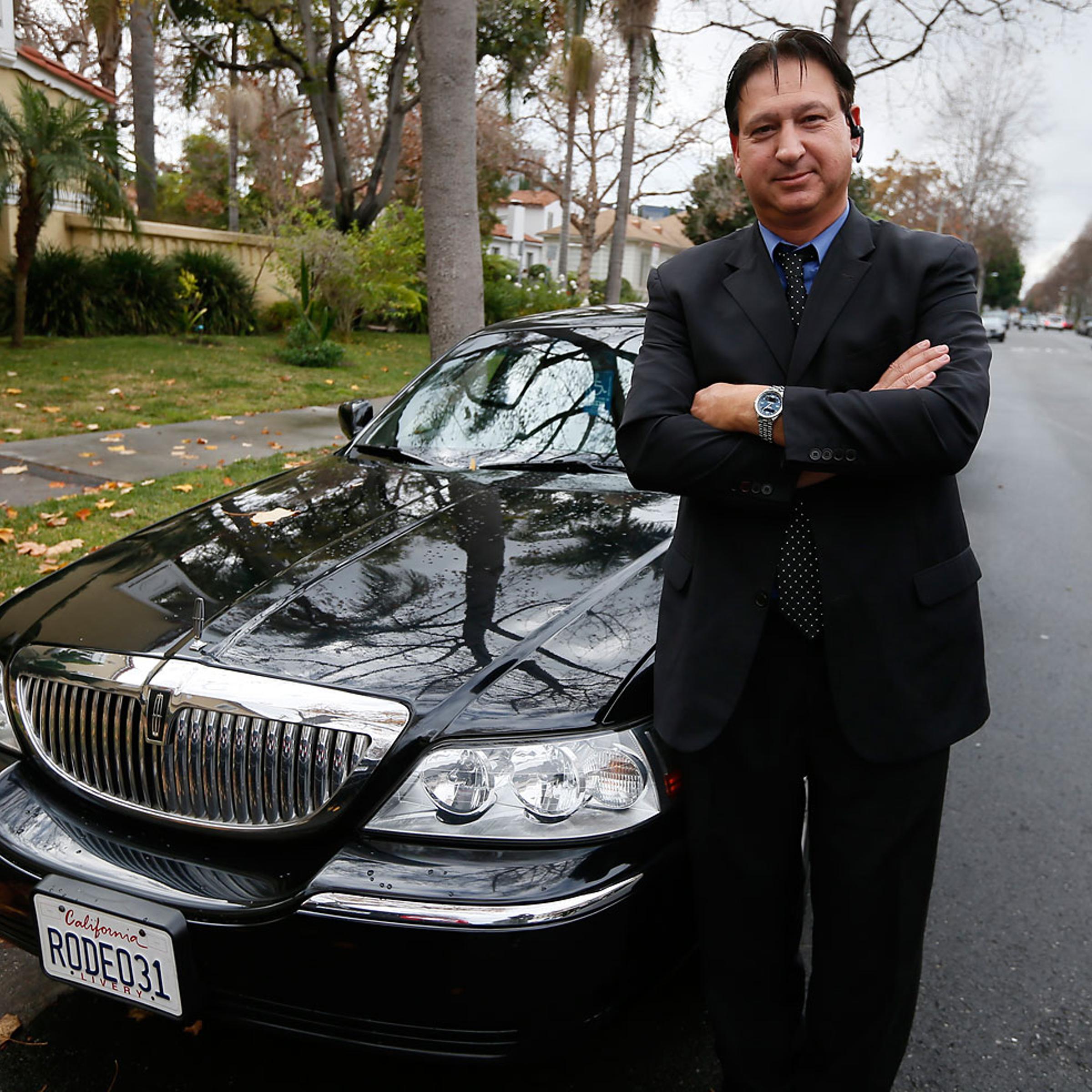 Transportation app Uber driver Shuki Zanna poses in front of his limousine in Beverly Hills