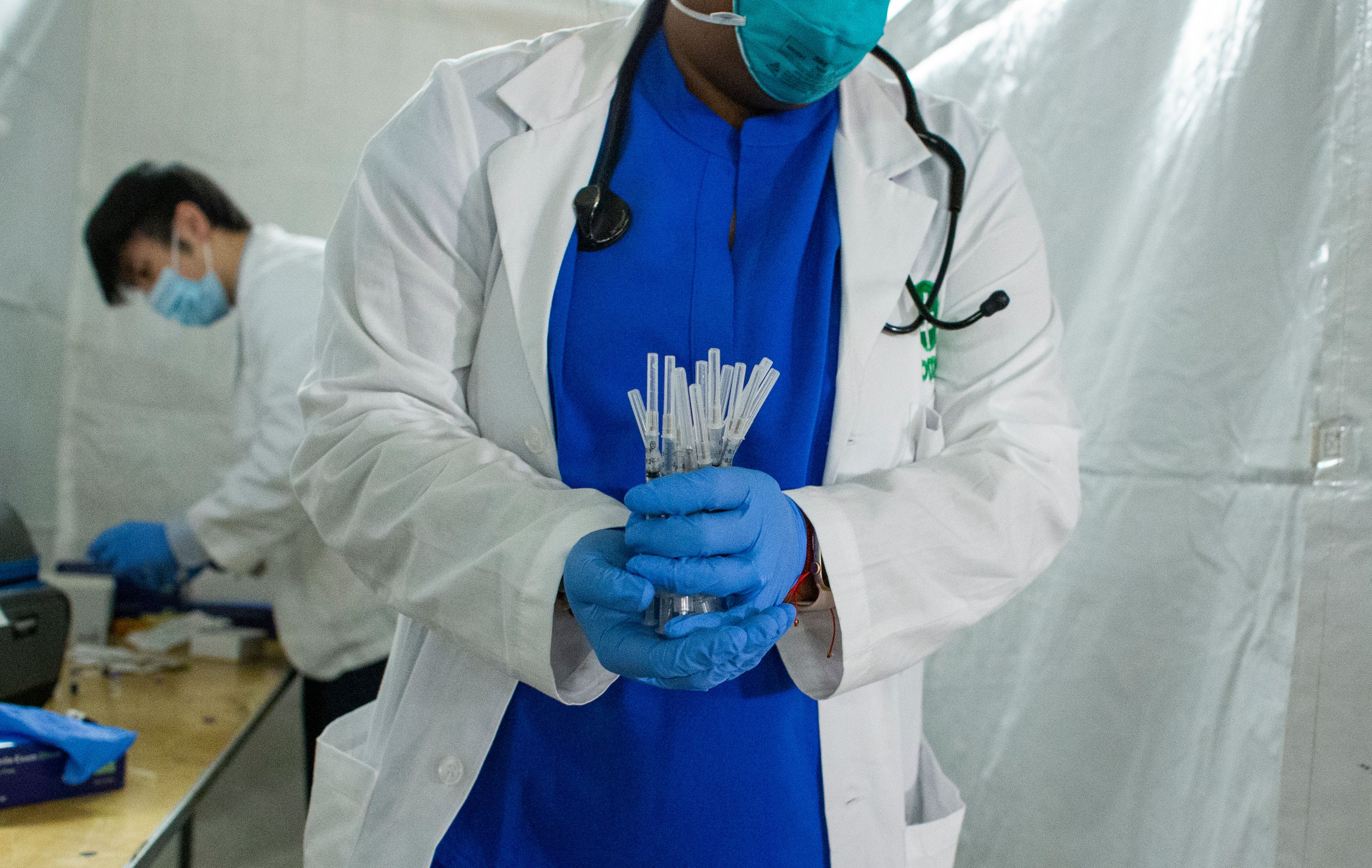 A health worker carries syringes to administer Pfizer Covid-19 vaccines at the opening of a new vaccination site at Corsi Houses in Harlem New York on January 15, 2021.