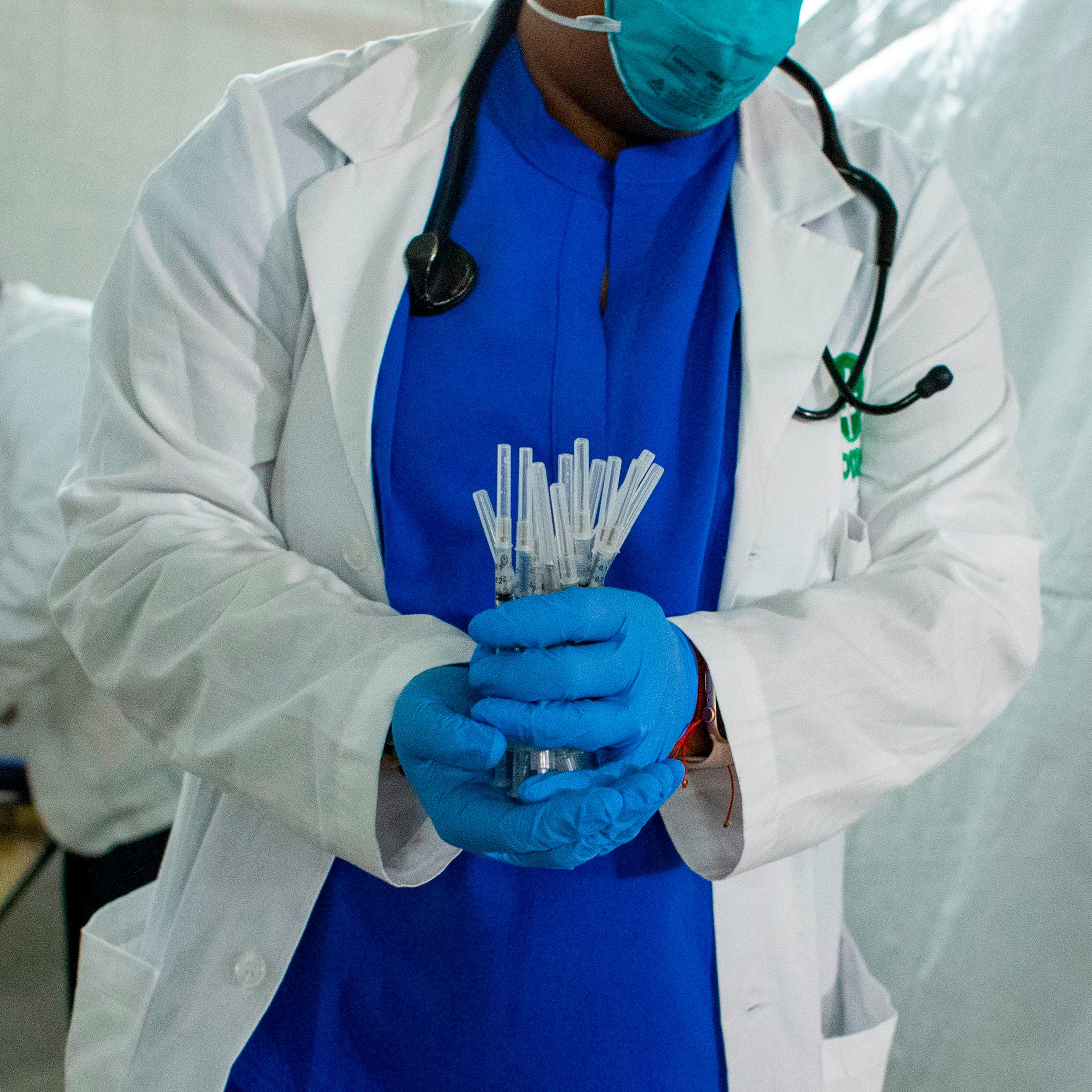 A health worker carries syringes to administer Pfizer Covid-19 vaccines at the opening of a new vaccination site at Corsi Houses in Harlem New York on January 15, 2021.