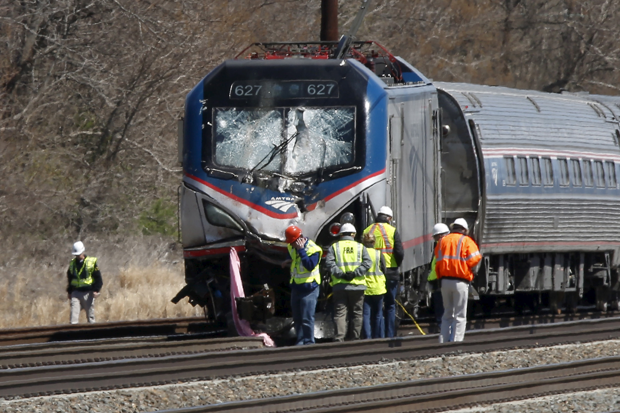 Emergency personnel examine the scene after an Amtrak passenger train struck a backhoe, killing two people, in Chester, Pennsylvania, April 3, 2016. The southbound Palmetto train running from New York to Savannah, Georgia, had about 341 passengers and se