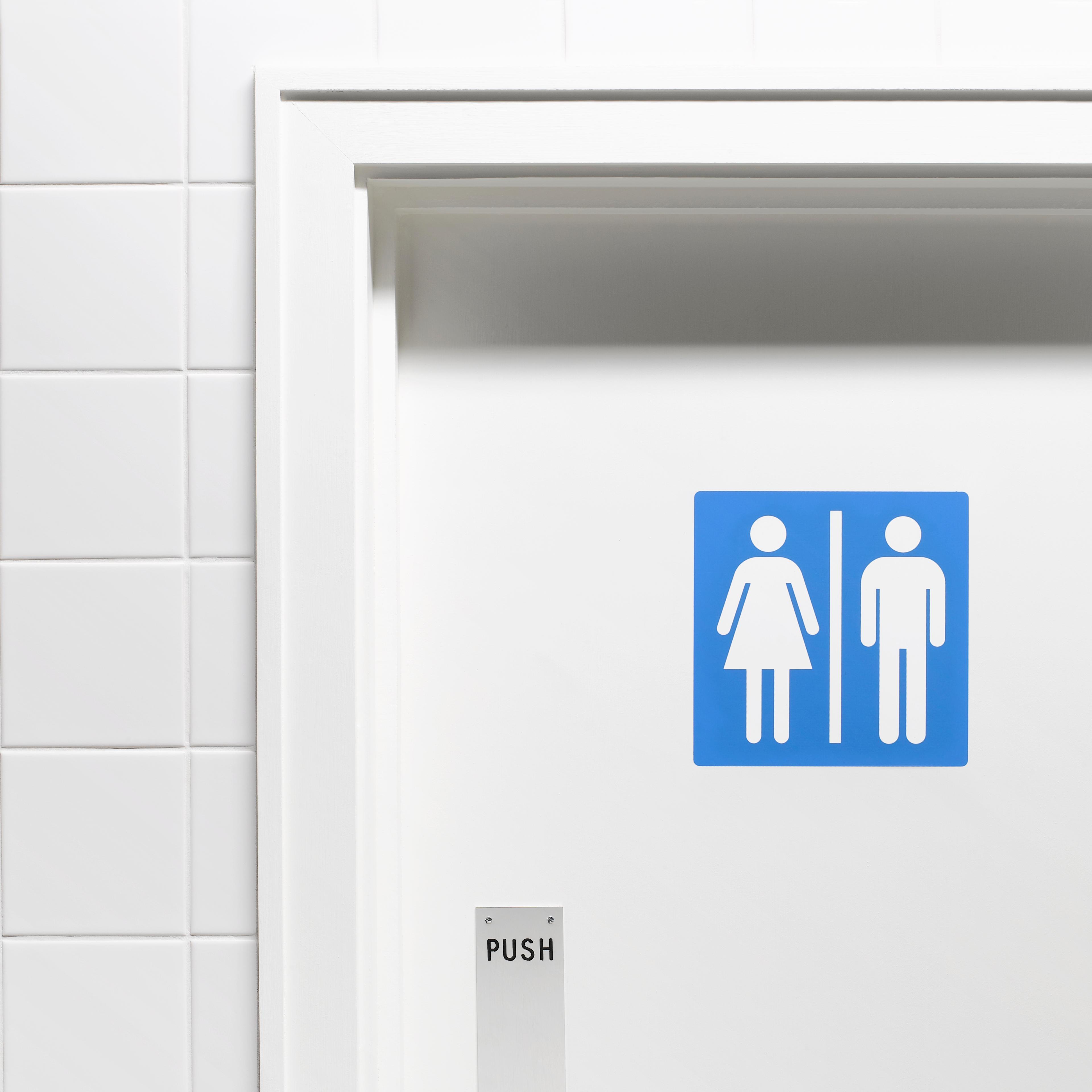 Female and male sign on toilet door, close-up