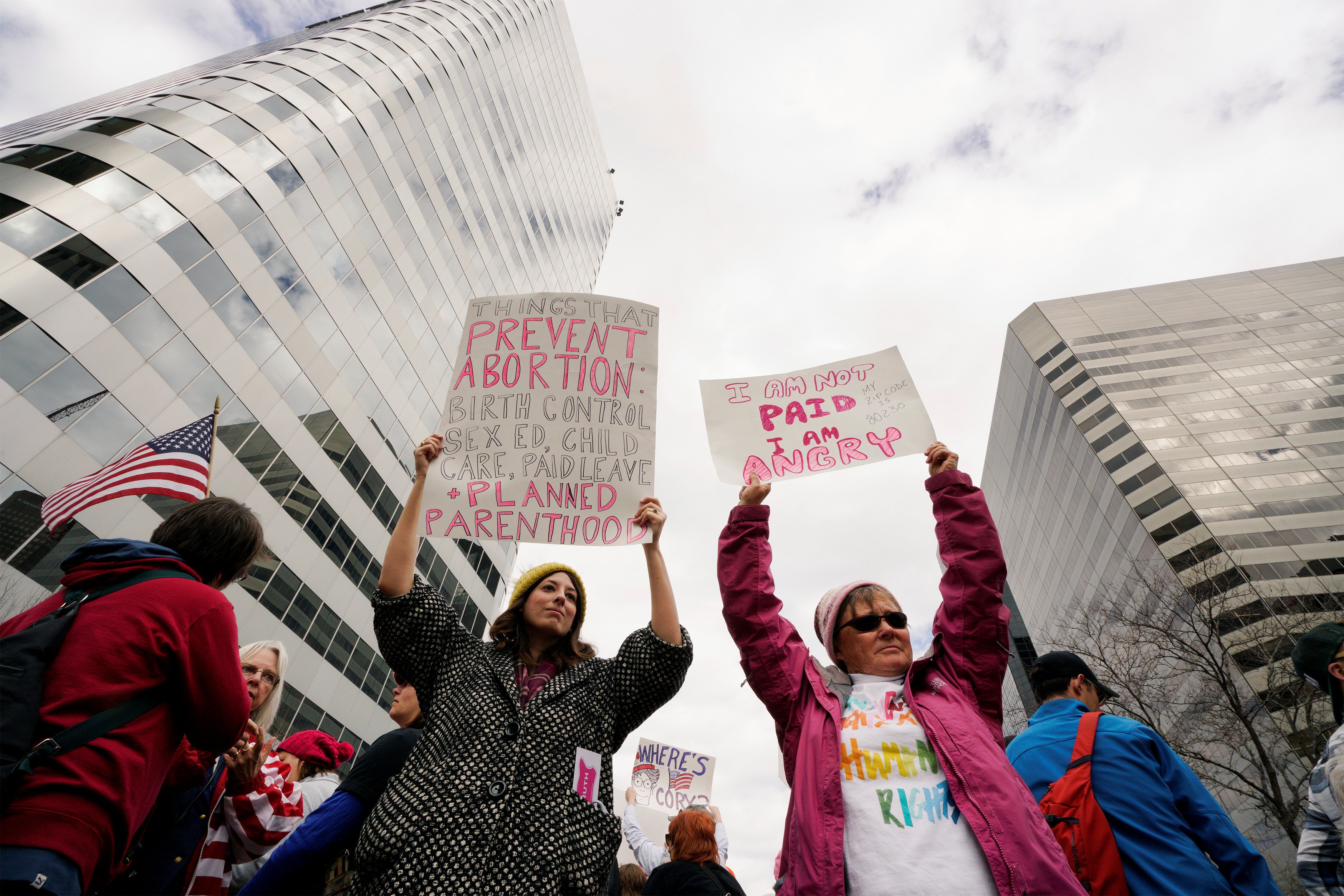 Planned Parenthood supporters hold signs at a protest in downtown Denver