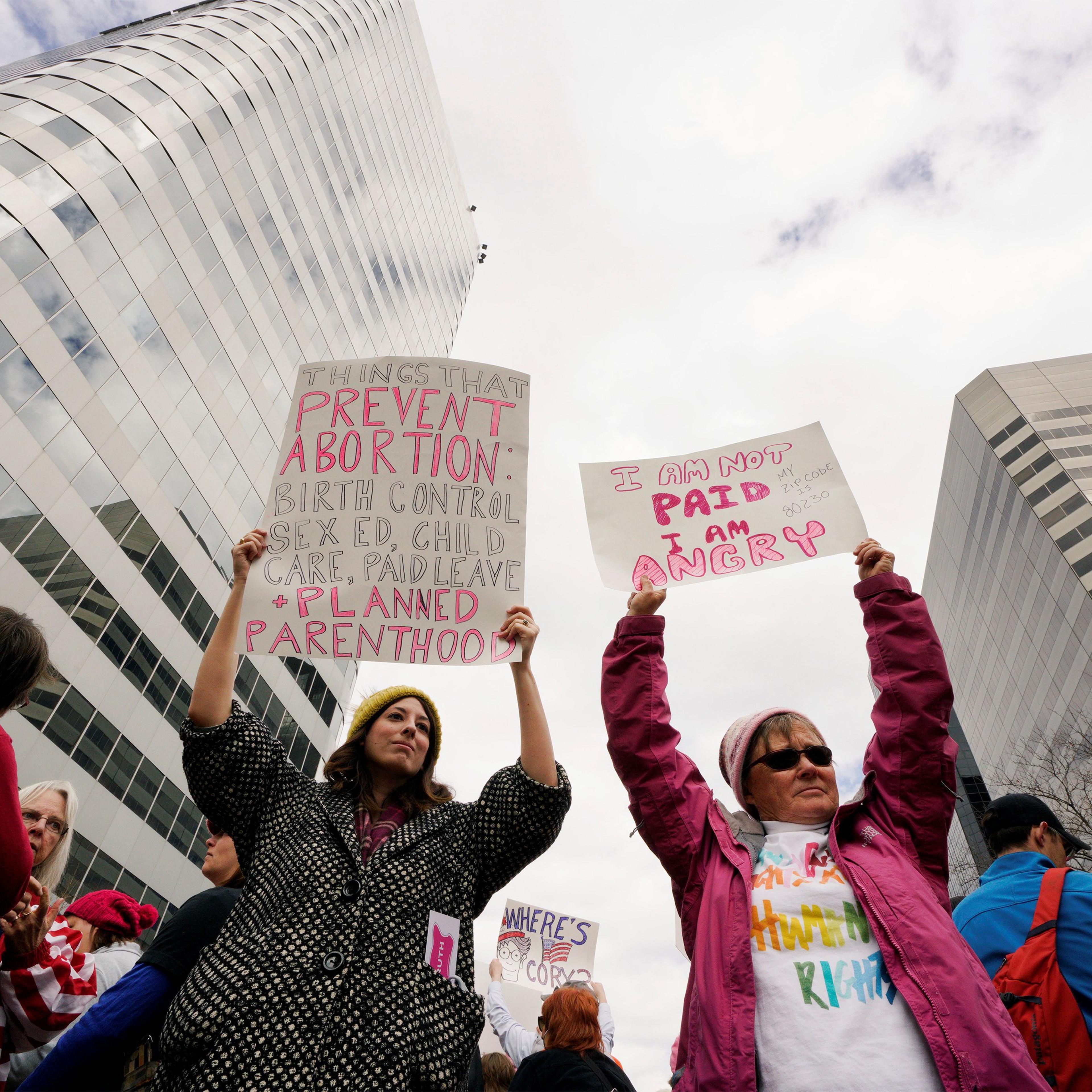 Planned Parenthood supporters hold signs at a protest in downtown Denver