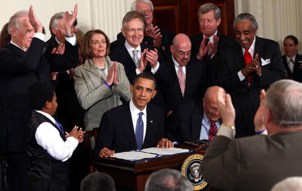U.S. President Barack Obama is applauded after signing the Affordable Health Care for America Act during a ceremony with fellow Democrats in the East Room of the White House March 23, 2010 in Washington, DC.