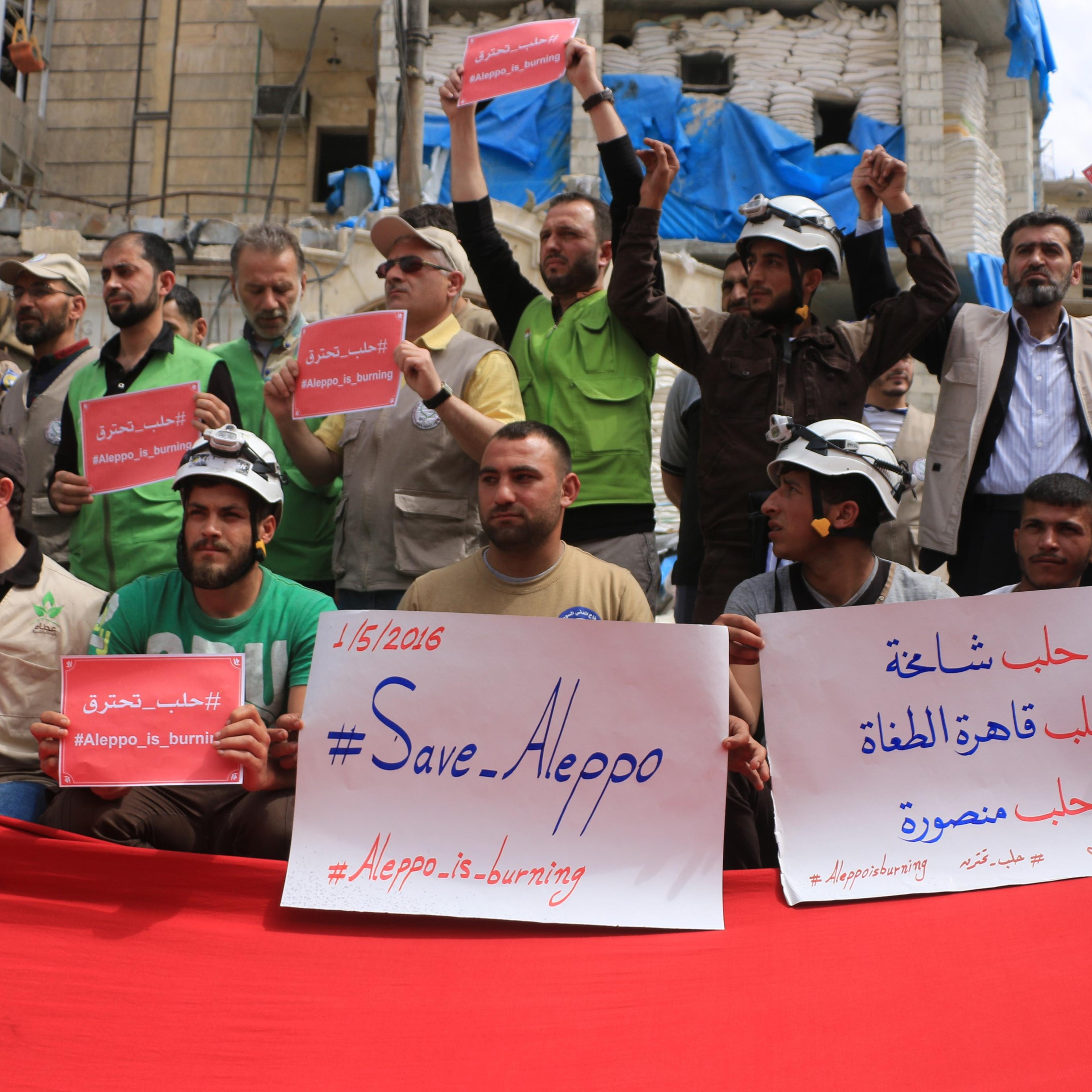Syrians hold banners during a protest against Russian airstrikes on Jerusalem field hospital in the Sukkeri neighborhood of Aleppo, Syria, on May 1, 2016.