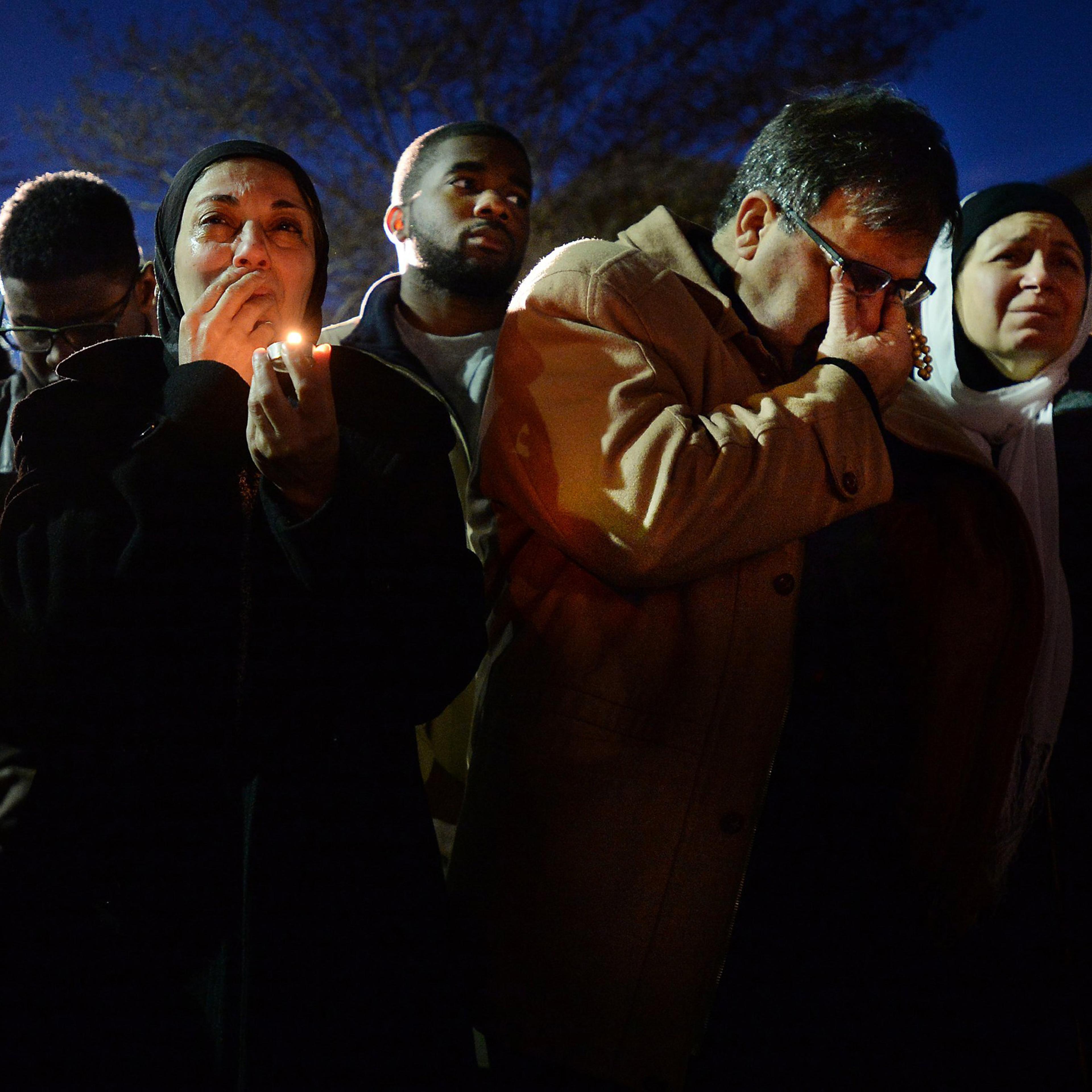 Namee Barakat (center) and his wife Layla (right) break into tears while watching a photo presentation during a vigil for his daughters on Feb. 11, 2015, in Chapel Hill, N.C.