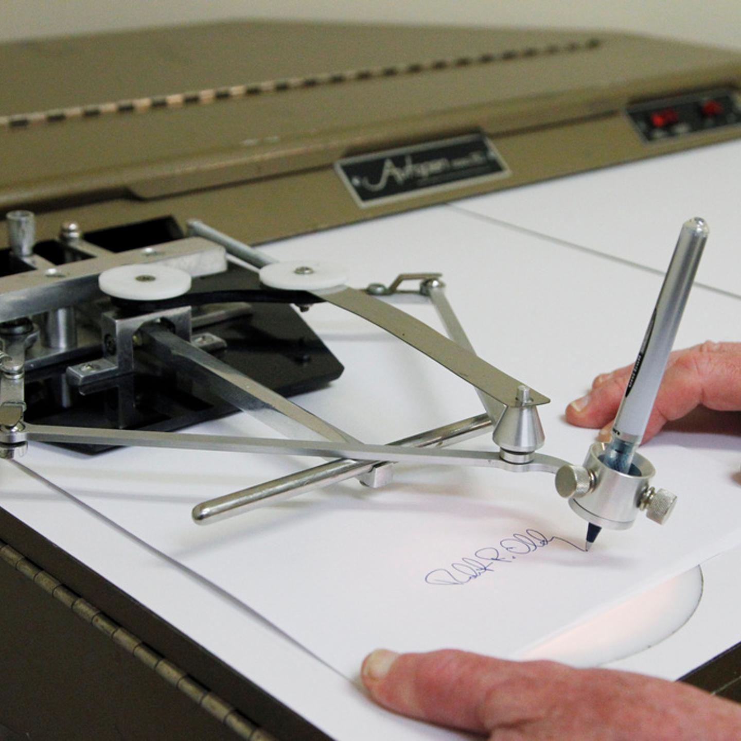 Bob Olding, president of Damilic Corp., the leading manufacture of automatic signing machines for replicating authentic signatures, demonstrates the features of the older model Autopen Model 80 in Rockville, Md., on June 13, 2011.