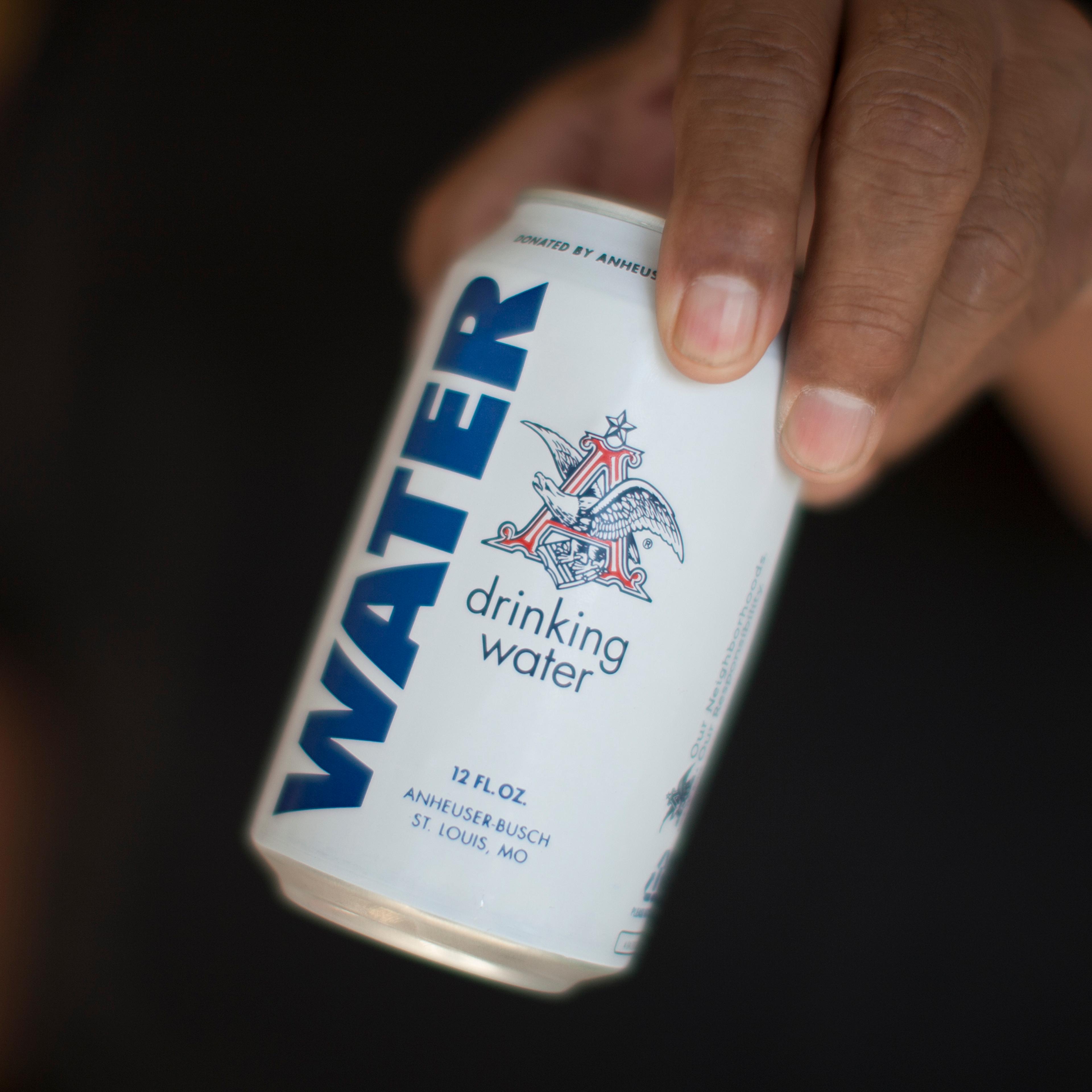 A resident holds a can of water donated by the Anheuser-Busch company as water wells supplying hundreds of residents remain dry in the fourth year of worsening drought on February 11, 2015 in East Porterville, California.