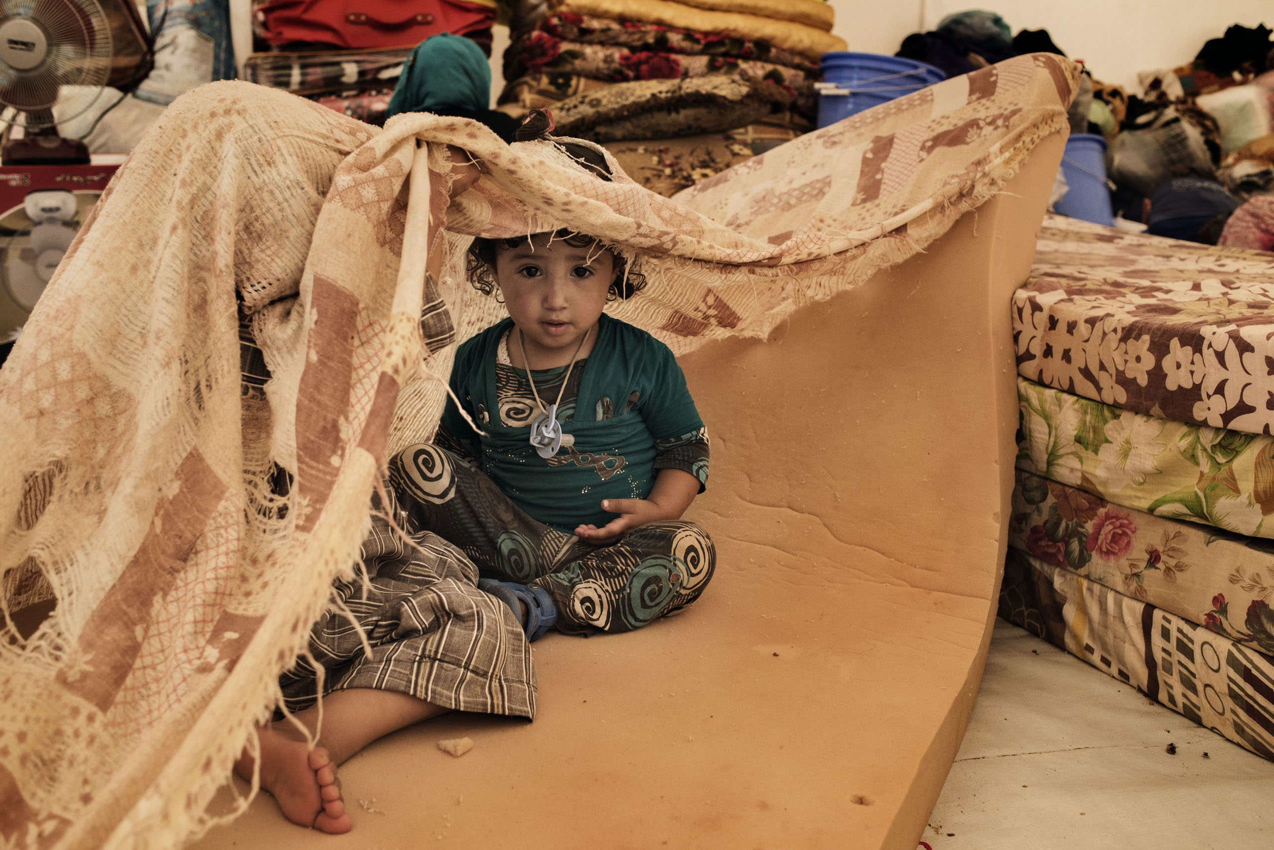 A displaced child sits in a tent in a camp near the Iraqi town of Makhmour, northern Iraq, May 2016. The United Nations said in April that as many as 30,000 people could be forced to flee instability in the Makhmour area, as the Iraqi military pursues an