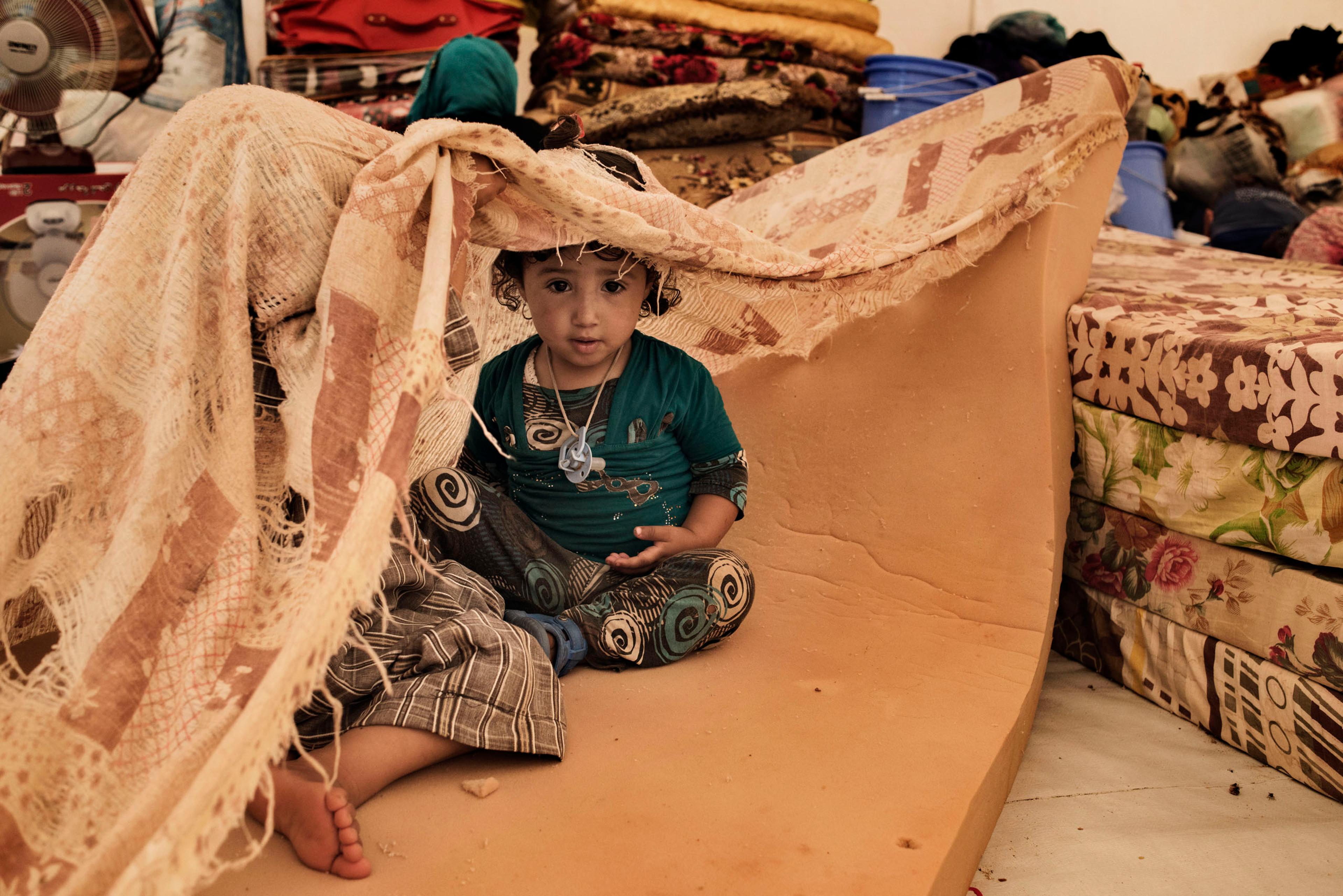A displaced child sits in a tent in a camp near the Iraqi town of Makhmour, northern Iraq, May 2016. The United Nations said in April that as many as 30,000 people could be forced to flee instability in the Makhmour area, as the Iraqi military pursues an
