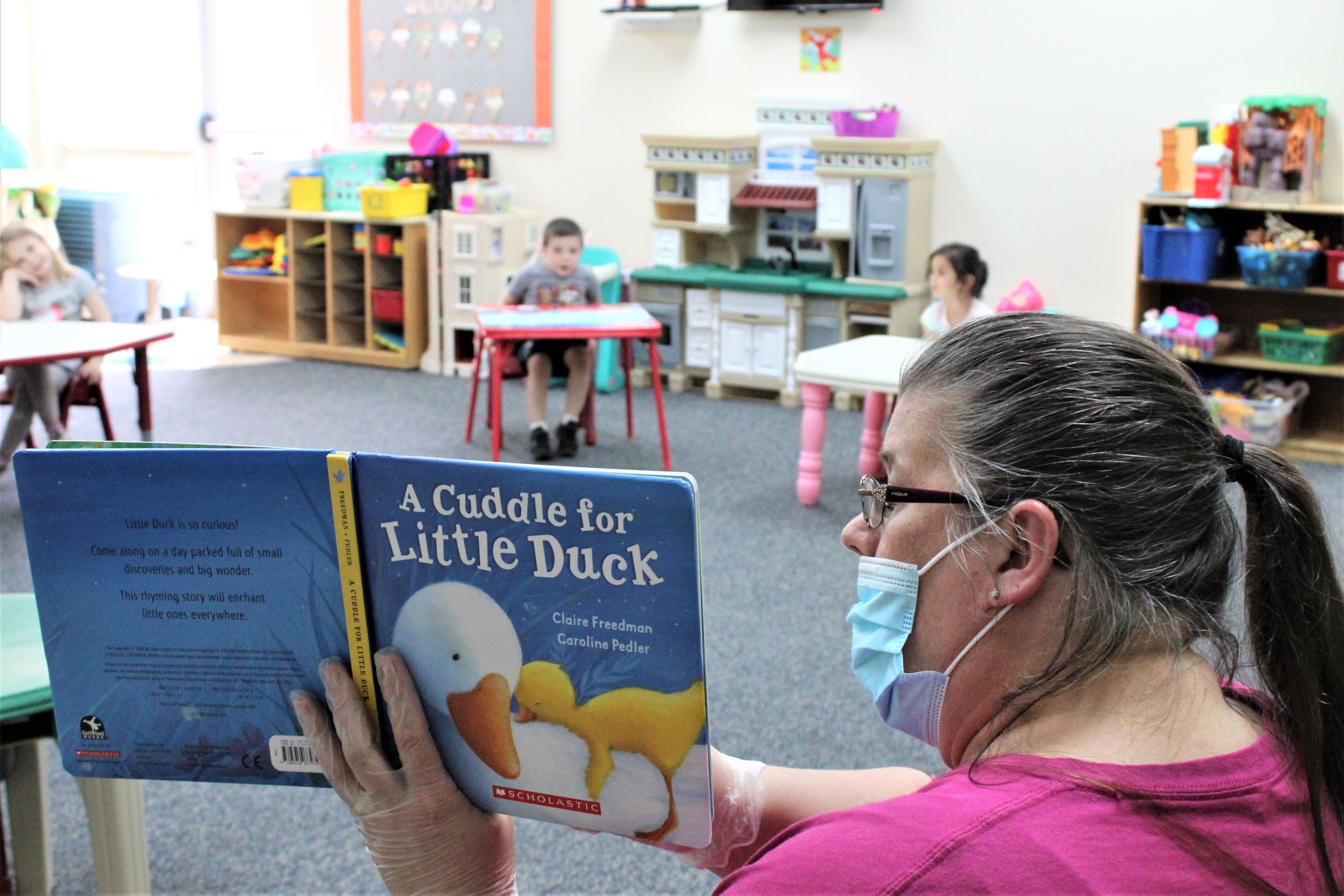 Daycare provider Darlene Mount reads to socially distanced children at a New Jersey YMCA