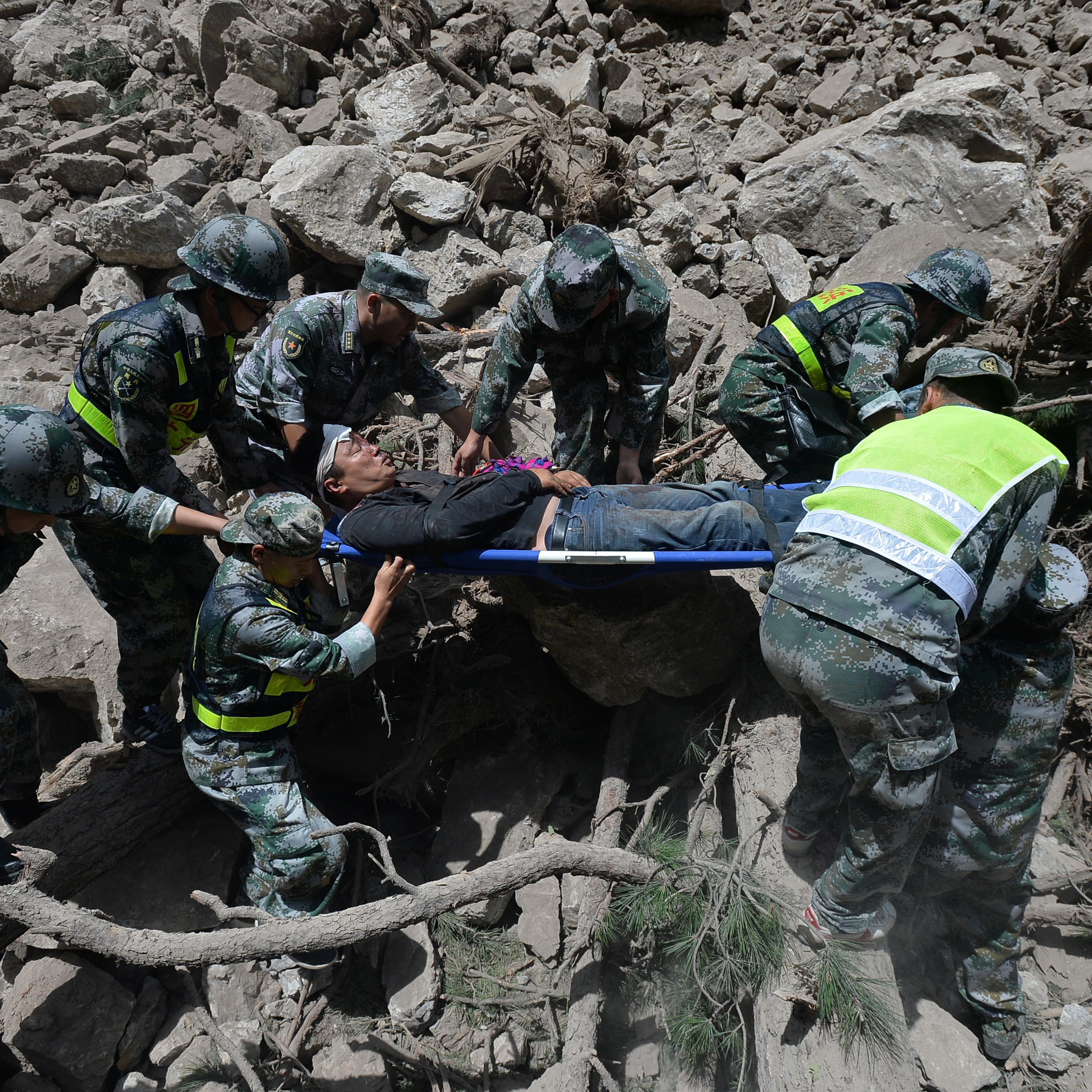 Chinese paramilitary police carry a survivor after an earthquake in Jiuzhaigou county