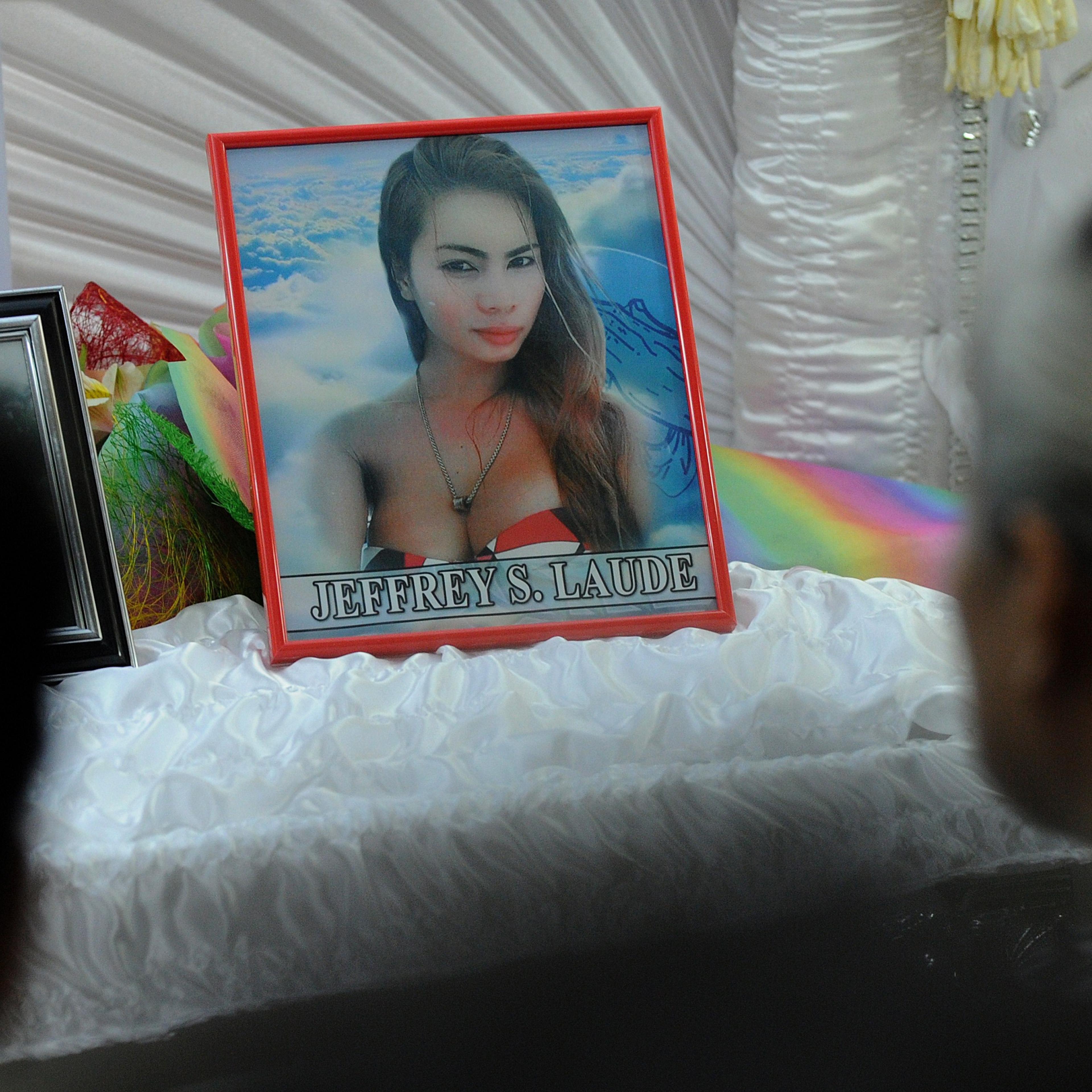 Friends and relatives of Filipino transgender resident Jeffrey Laude look on alongside his coffin and photograph in the northern Philippine city of Olongapo on Oct. 14, 2014.