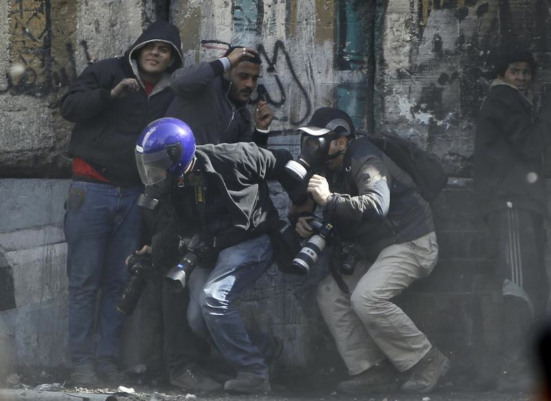 Photographers cower as protesters throw stones towards riot police along Sheikh Rihan street near Tahrir Square in Cairo January 25, 2013.