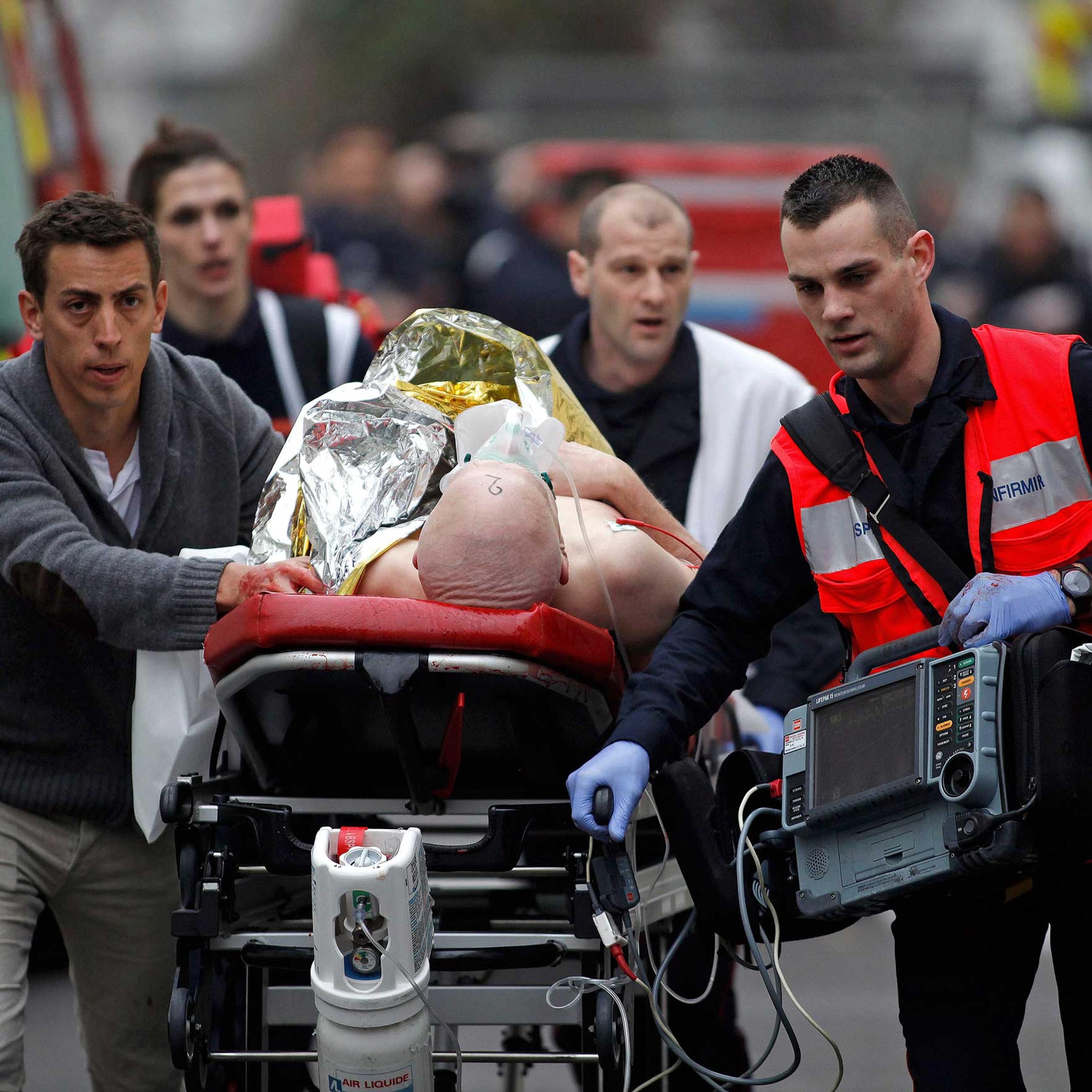 An injured person is evacuated outside the French satirical newspaper Charlie Hebdo's office, in Paris, Jan. 7, 2015. Police official says 11 dead in shooting at the French satirical newspaper.