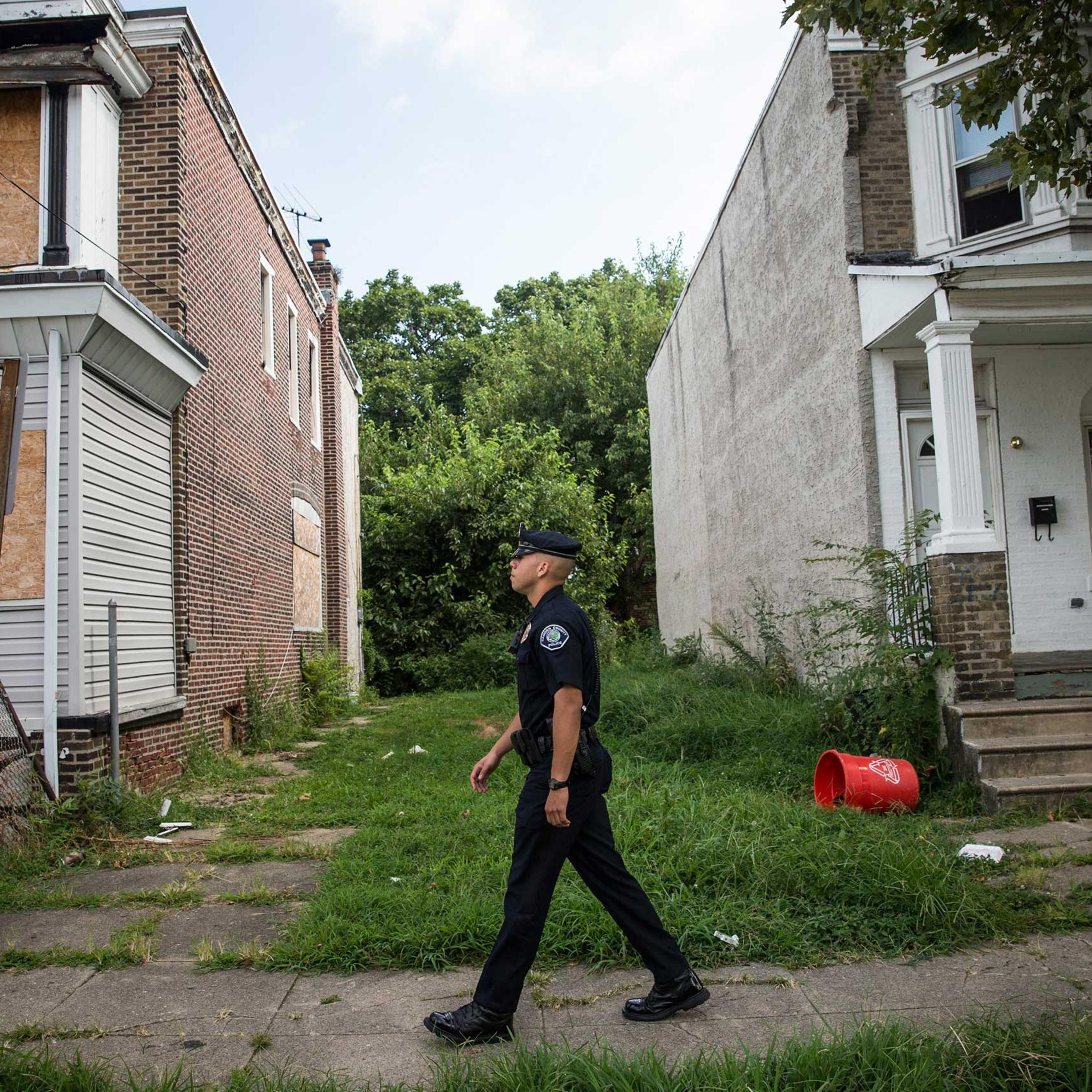 Officer Adam Fulmore, of the Camden County Police Department, goes on a foot patrol in the Parkside neighborhood of Camden, N.J. on Aug. 22, 2013.