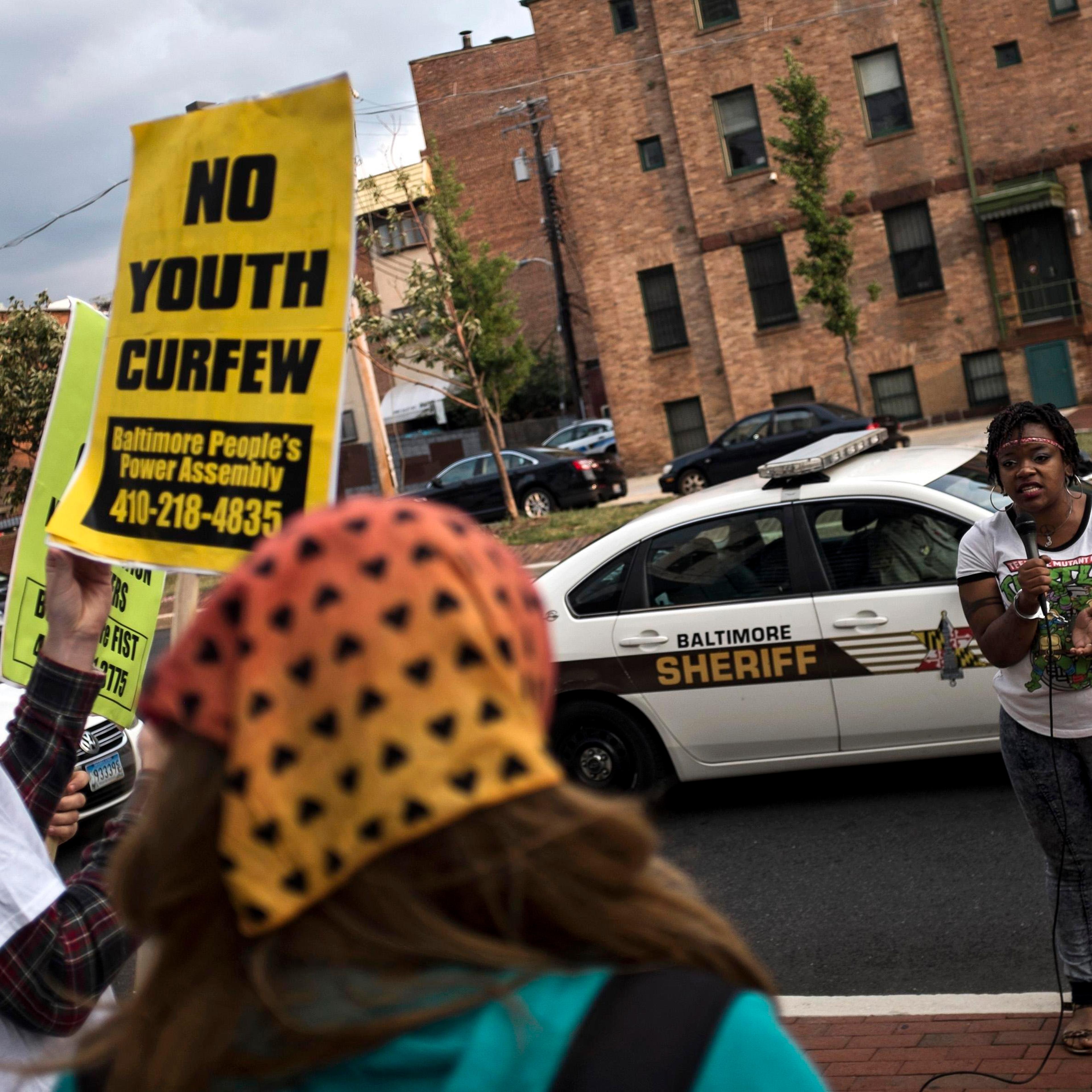 Protesters demonstrate before community meeting with city officials about new youth curfew legislation in Baltimore