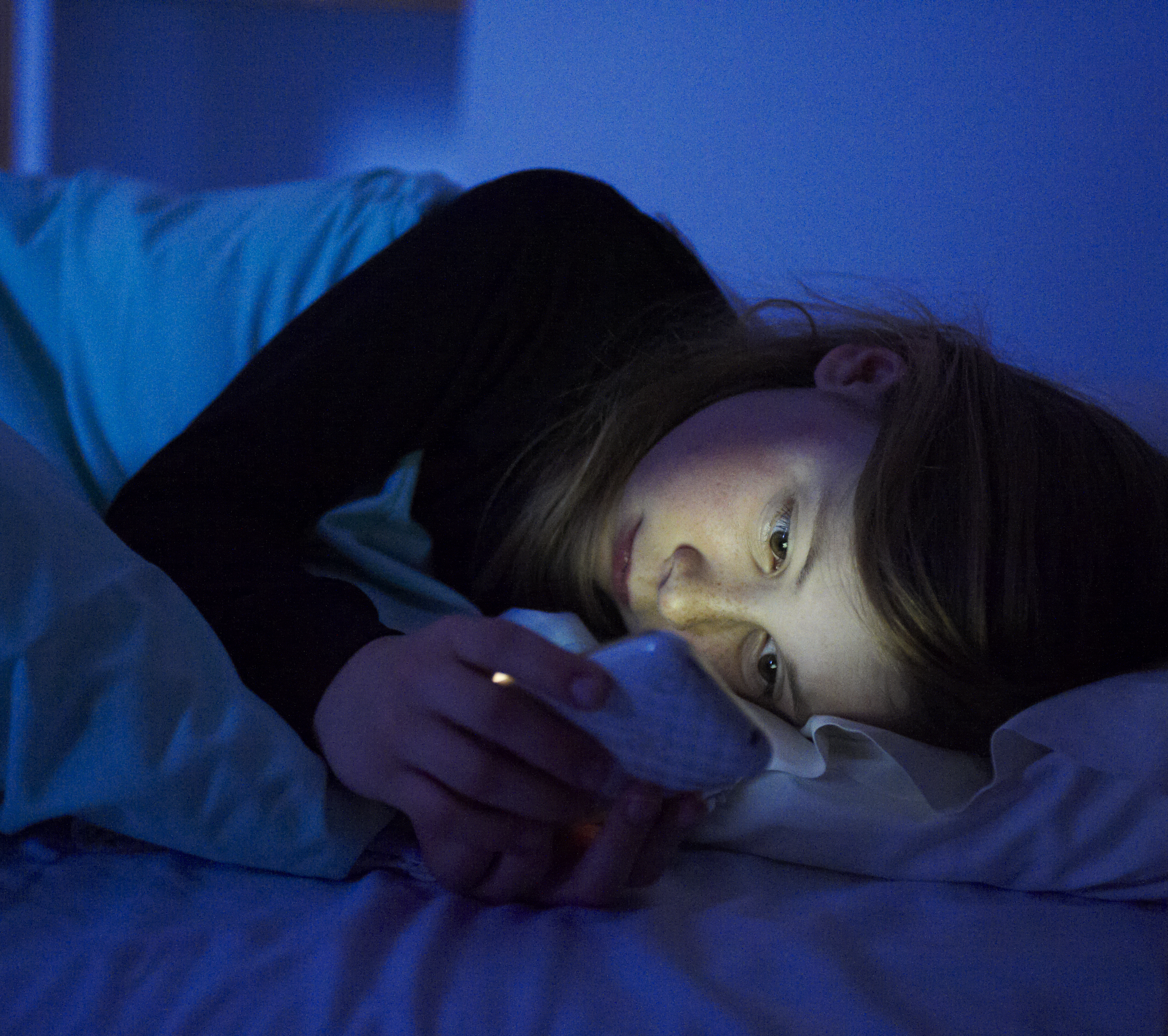 woman-cellphone-bed-nightime