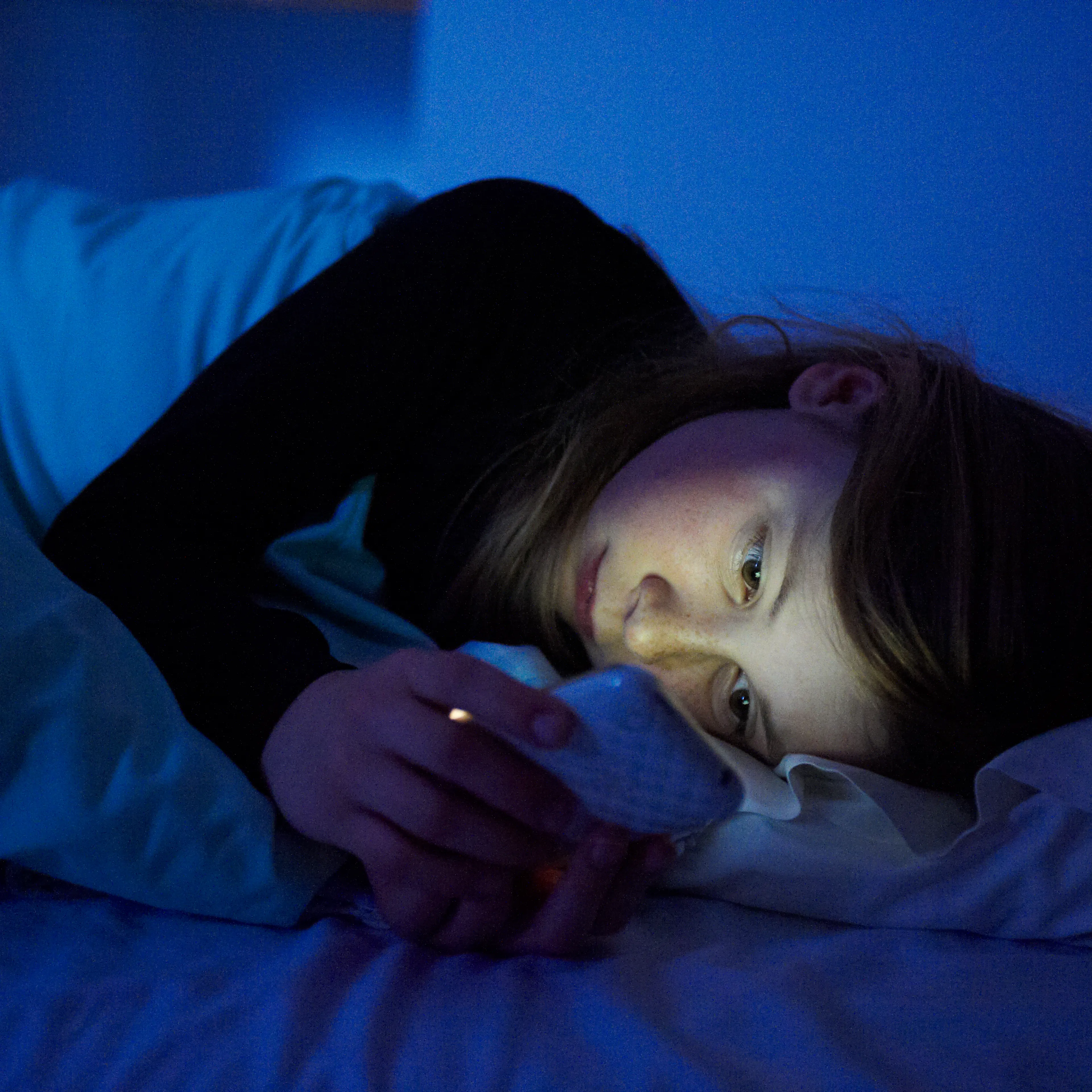 woman-cellphone-bed-nightime