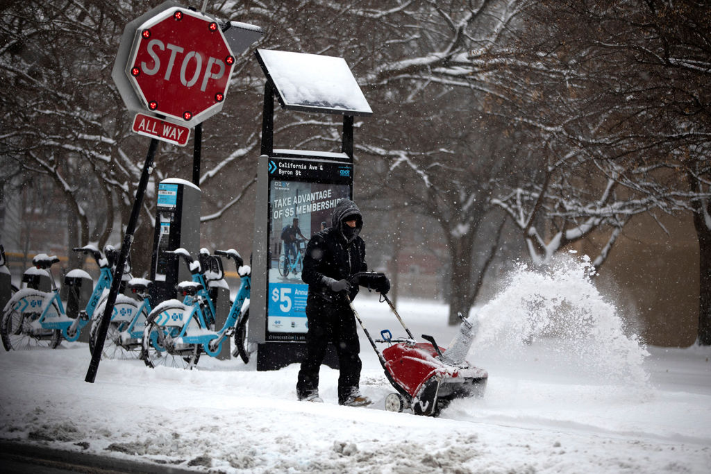 Snow is removed from the sidewalk in front of the McFetridge Sports Center in Chicago