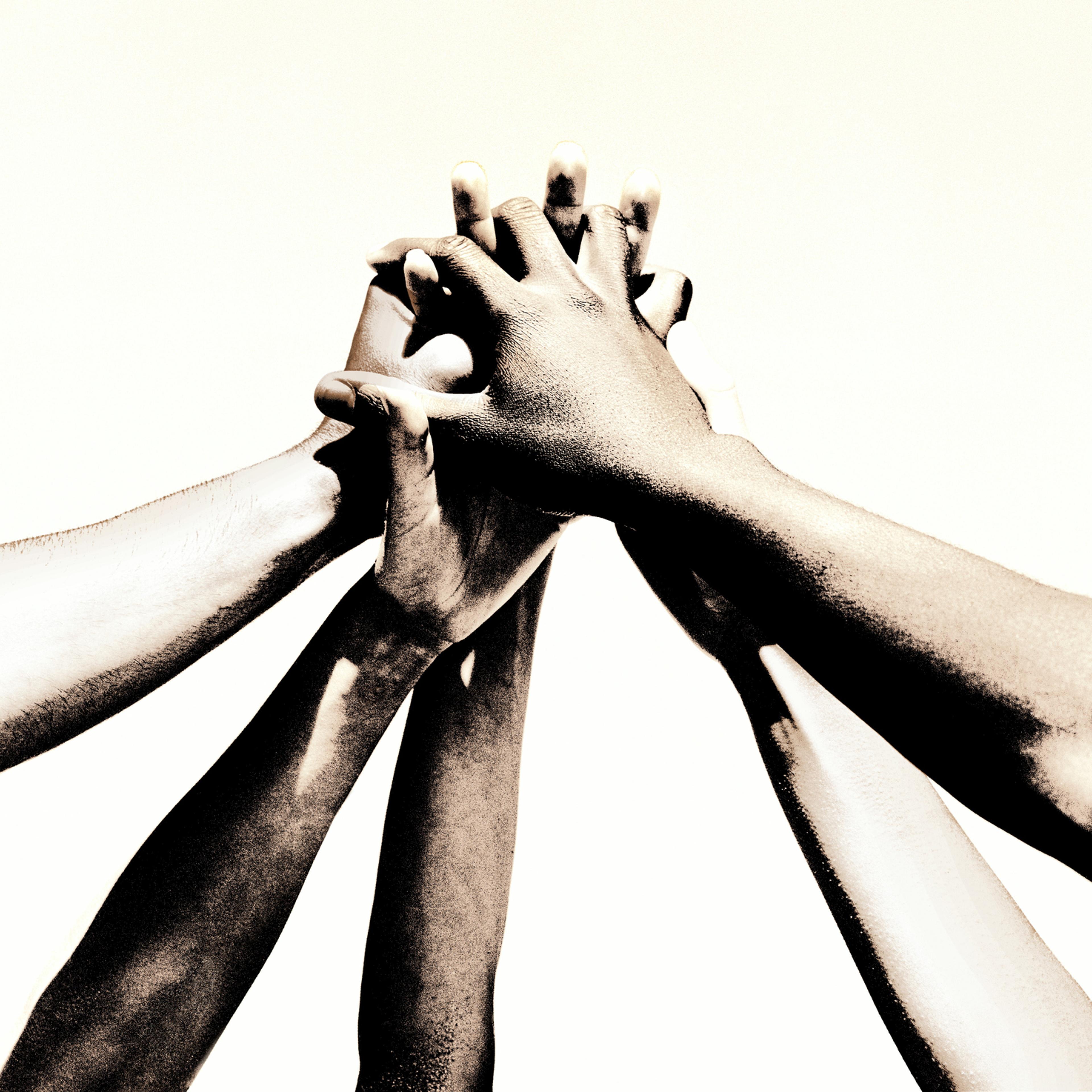 Group of young people's hands clasped together